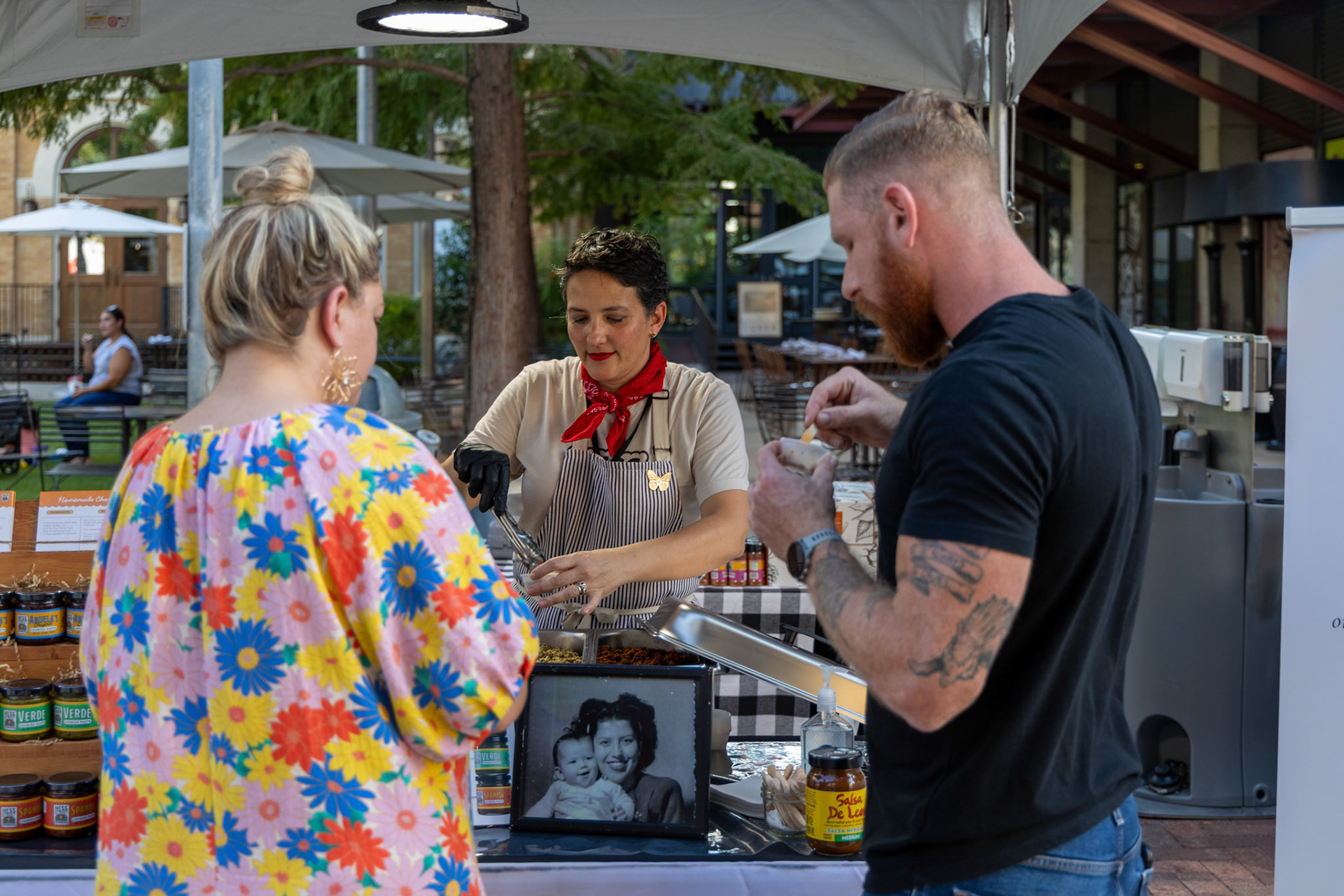 Maria Flores of Hess Street Foods gives customers samples of chorizo made with Abuela’s Original Chorizo Paste at her booth during the Quest for Texas Best showcase at the Pearl on Sept. 24, 2025.