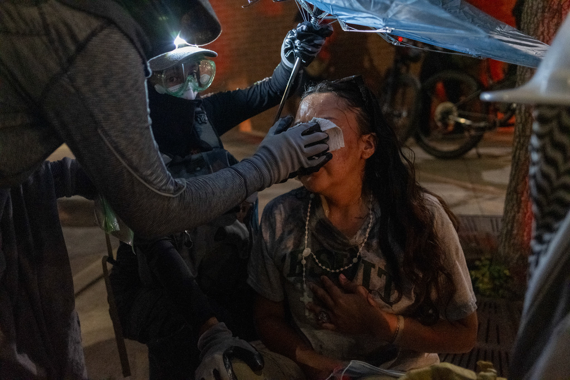Two women assist a protester after she was pepper-sprayed during a protest following the ‘No Kings’ rally through the streets of downtown Austin, Texas, on June 14, 2025.
