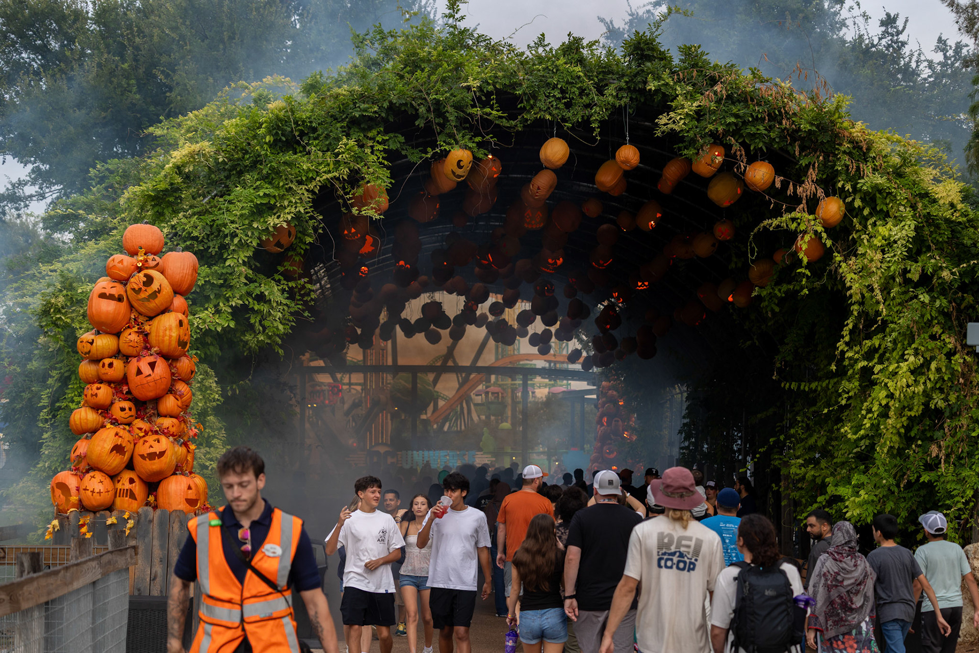 Parkgoers walk through a covered walkway decorated with jack-o’-lanterns at Six Flags Fiesta Texas in San Antonio on Sept. 6, 2025.