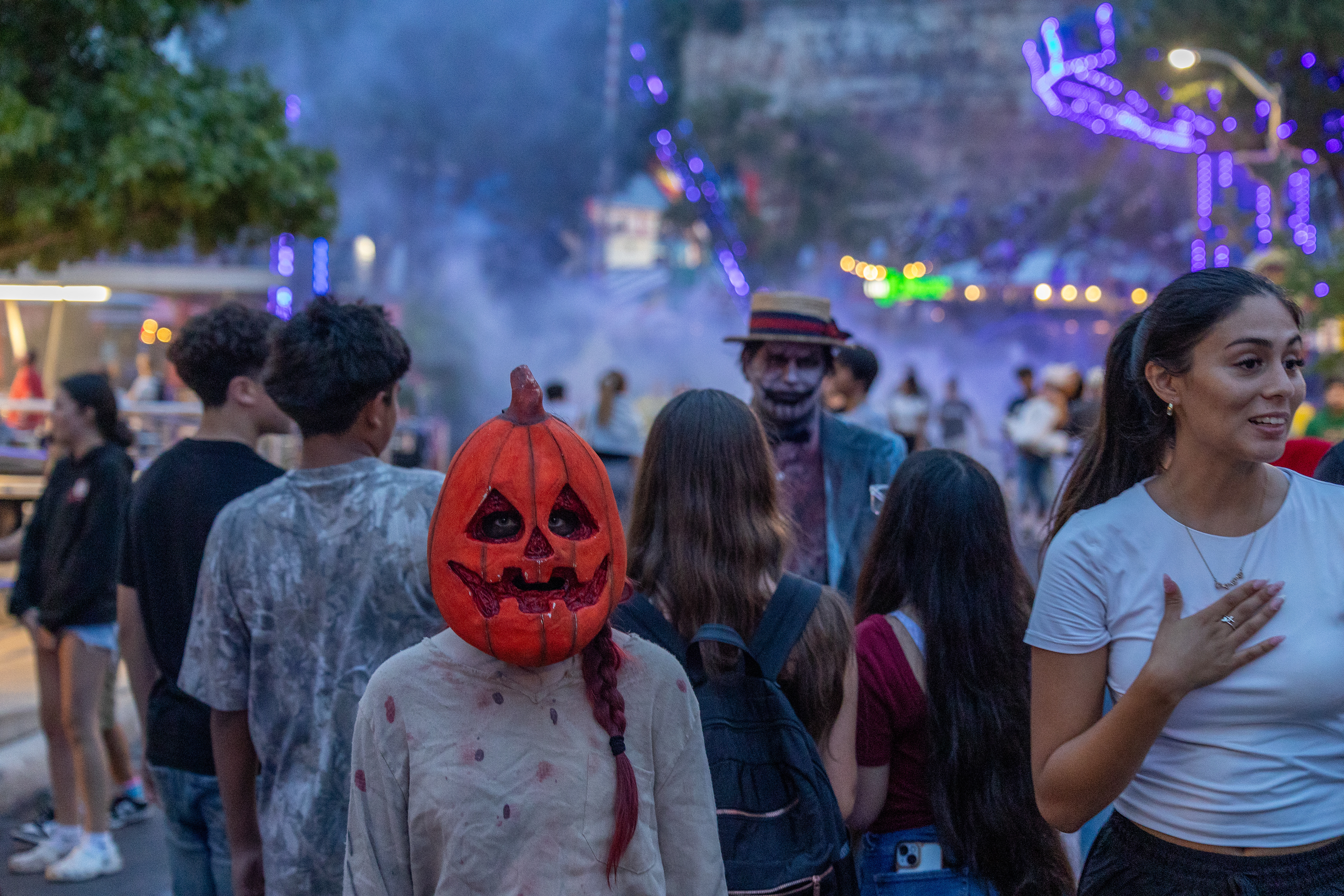 Parkgoers walk through Fright Fest actors in a scare zone on the opening night of Fright Fest at Six Flags Fiesta Texas in San Antonio on Sept. 6, 2025.
