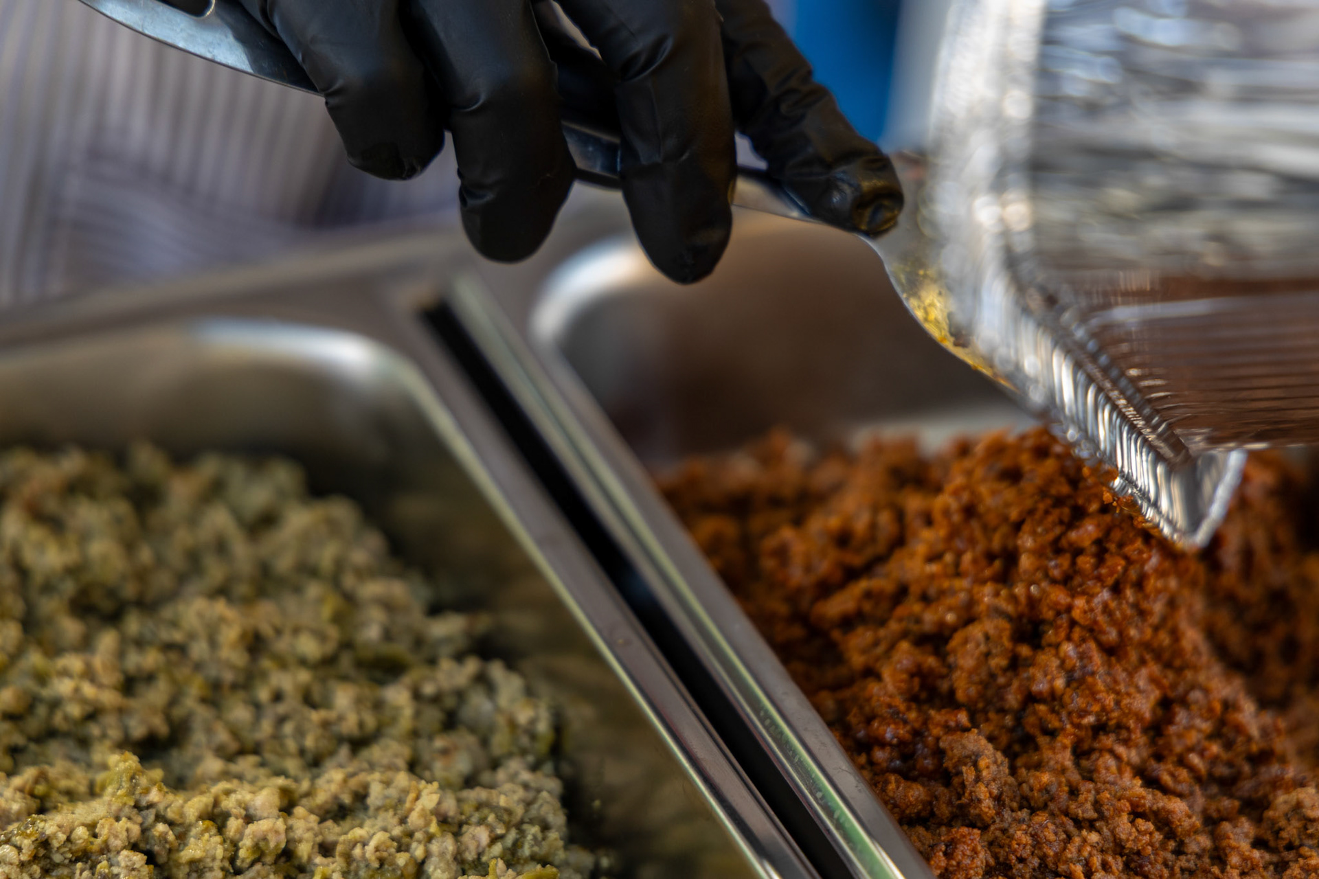 Maria Flores prepares chorizo made with Abuela’s Original Chorizo Paste for sampling at her booth during the Quest for Texas Best showcase at the Pearl on Sept. 24, 2025.