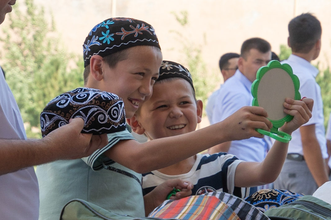 Young boys buying hats, Shakhrisabz, Uzbekistan, 2019