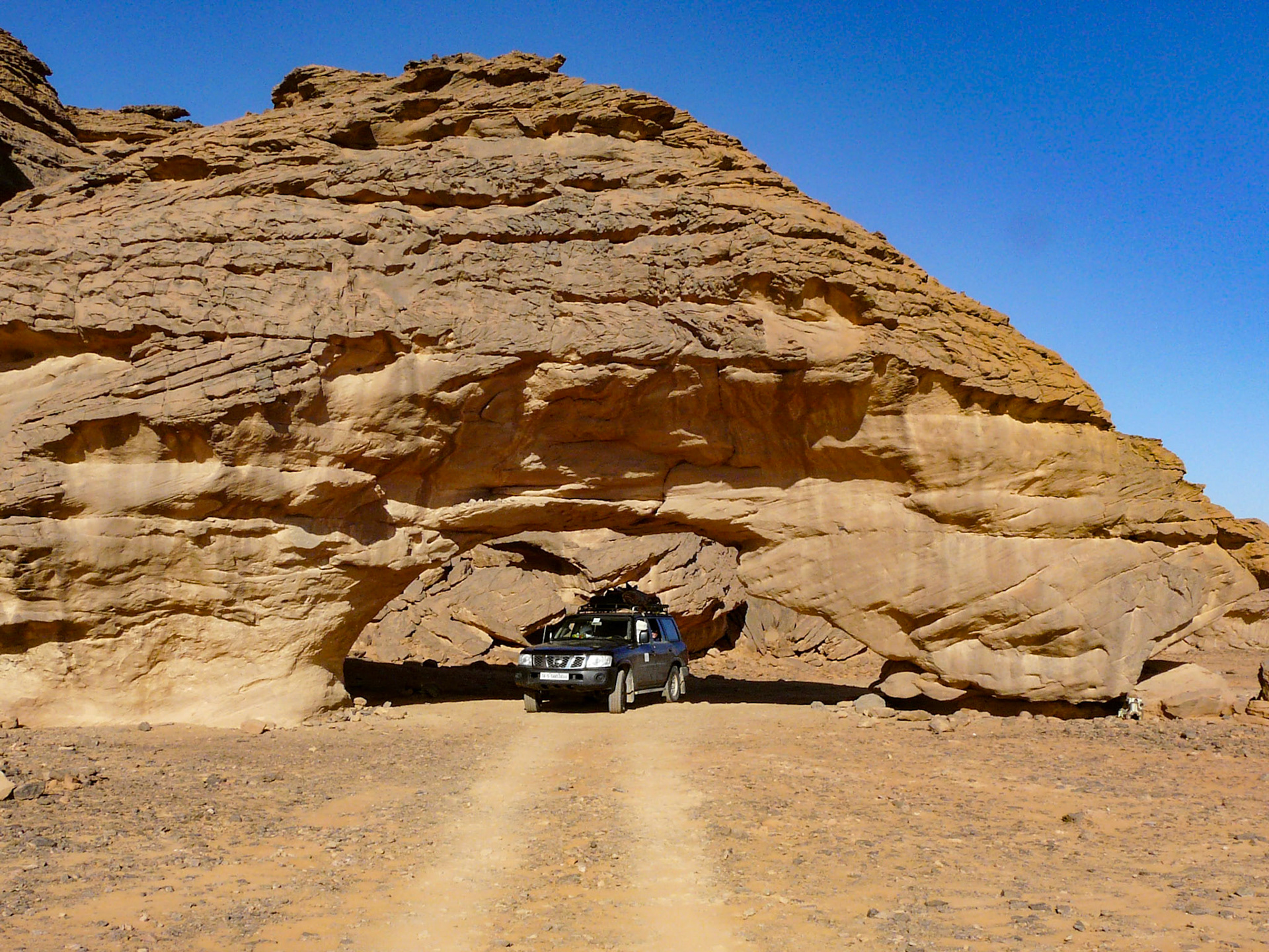 Driving through Rock arch, Northern Akakus