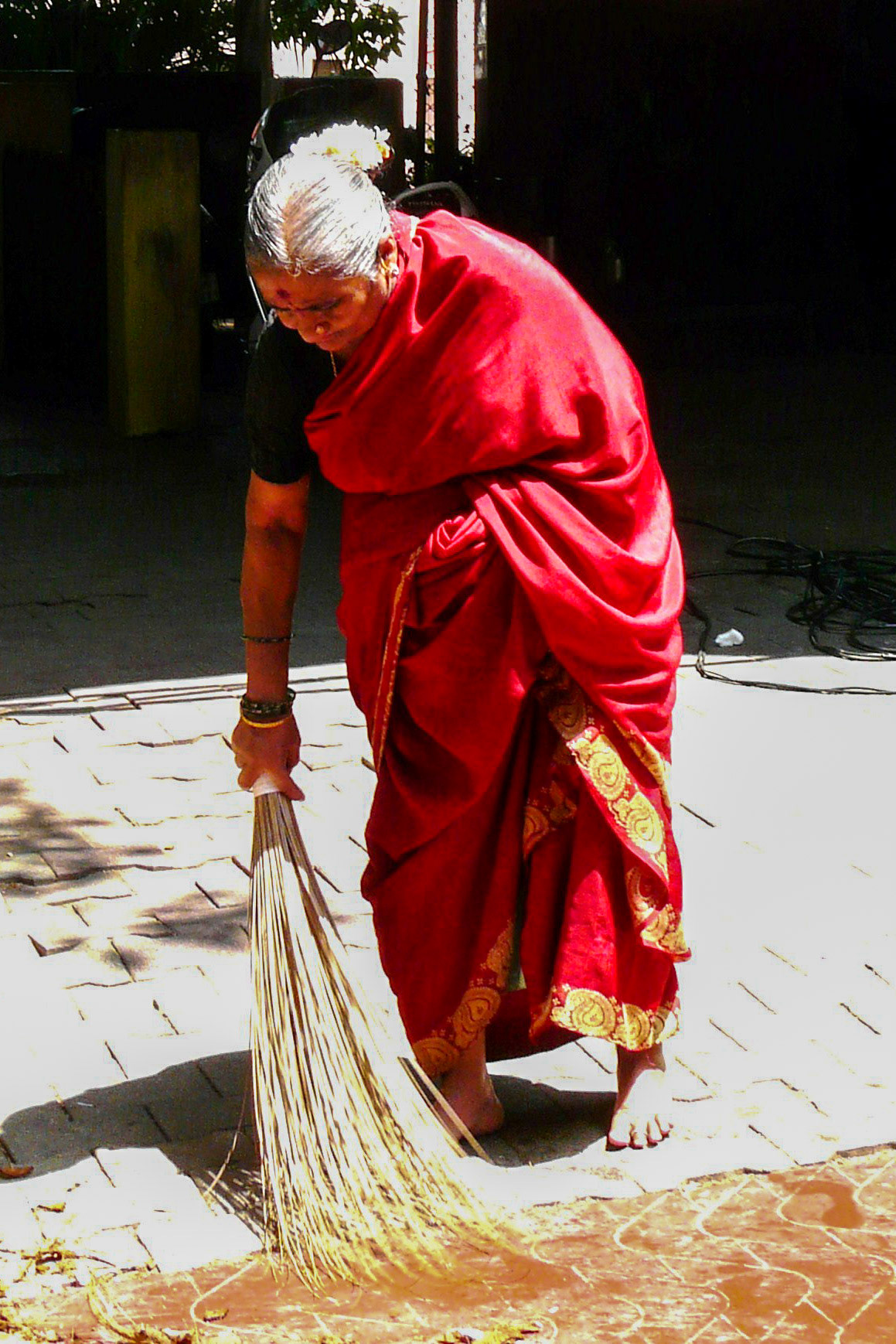 Lady sweeping street, Bangalore, India
