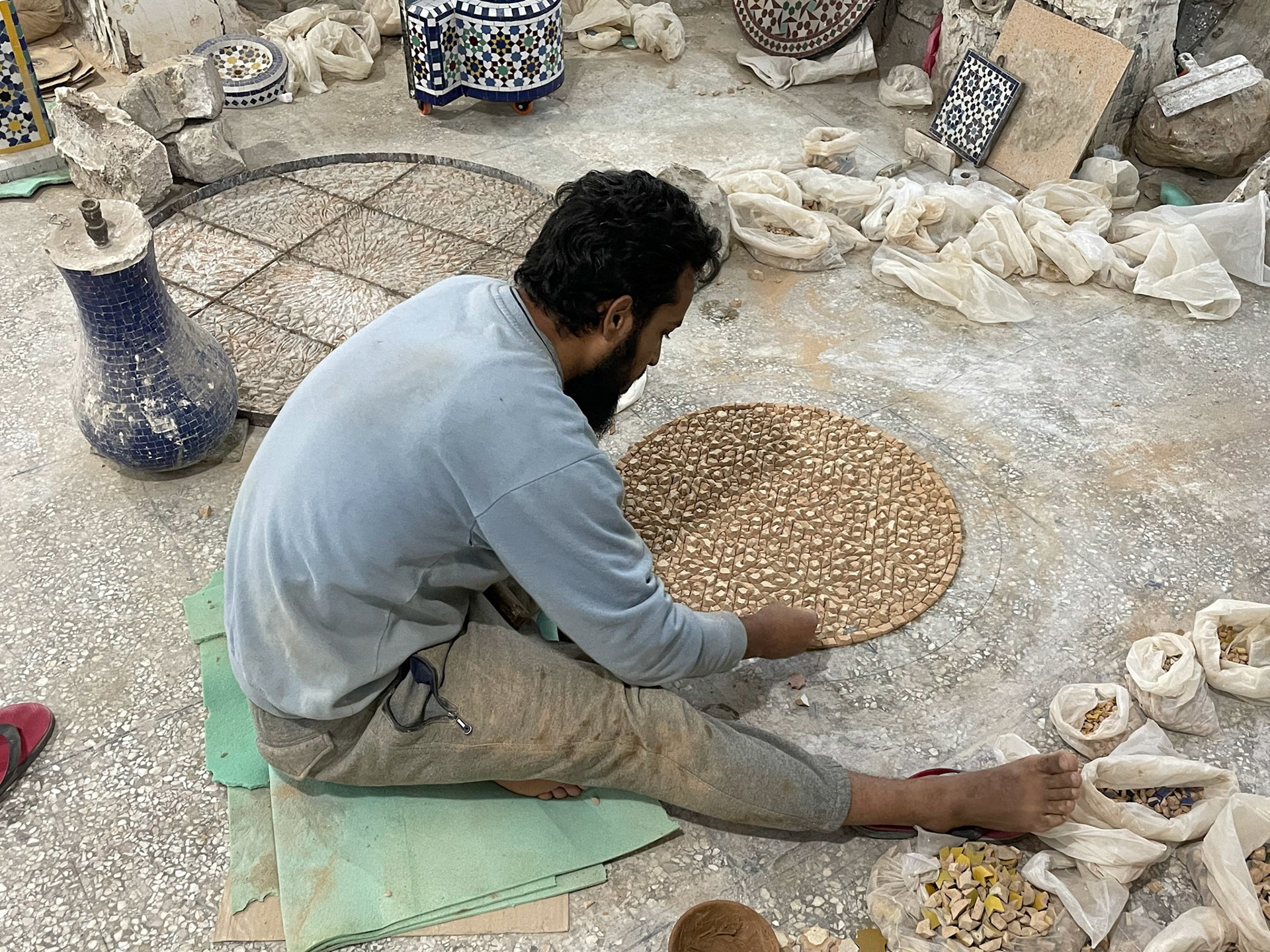 Laying down pieces for mosaic table, Mosaic and pottery workshop, Fes, Morocco