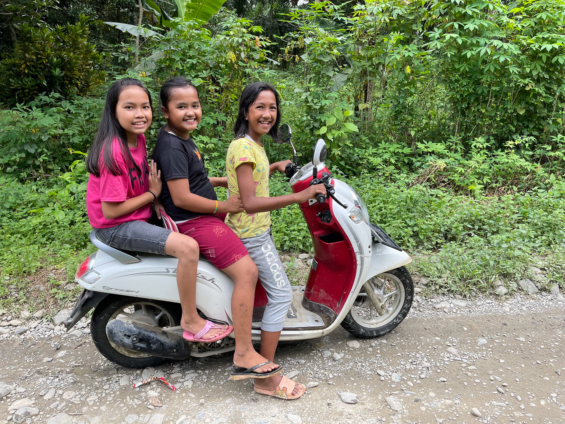 Three girls on a motorbike, Tangkahan, Sumatra, Indonesia, 2022