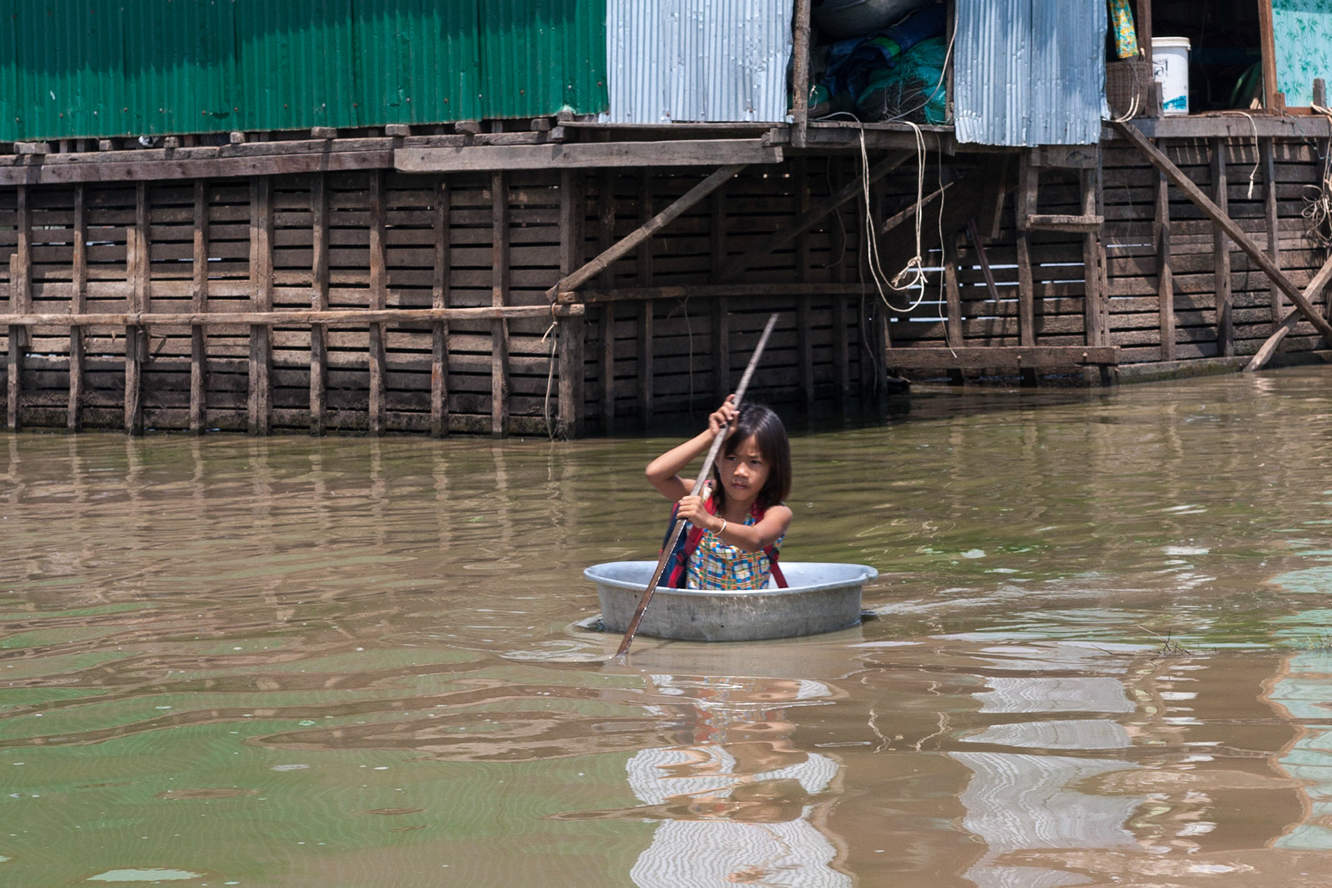 A young Girl rowing on her way back from school in a floating Vietnamese fishing village on Tonle Sap Lake