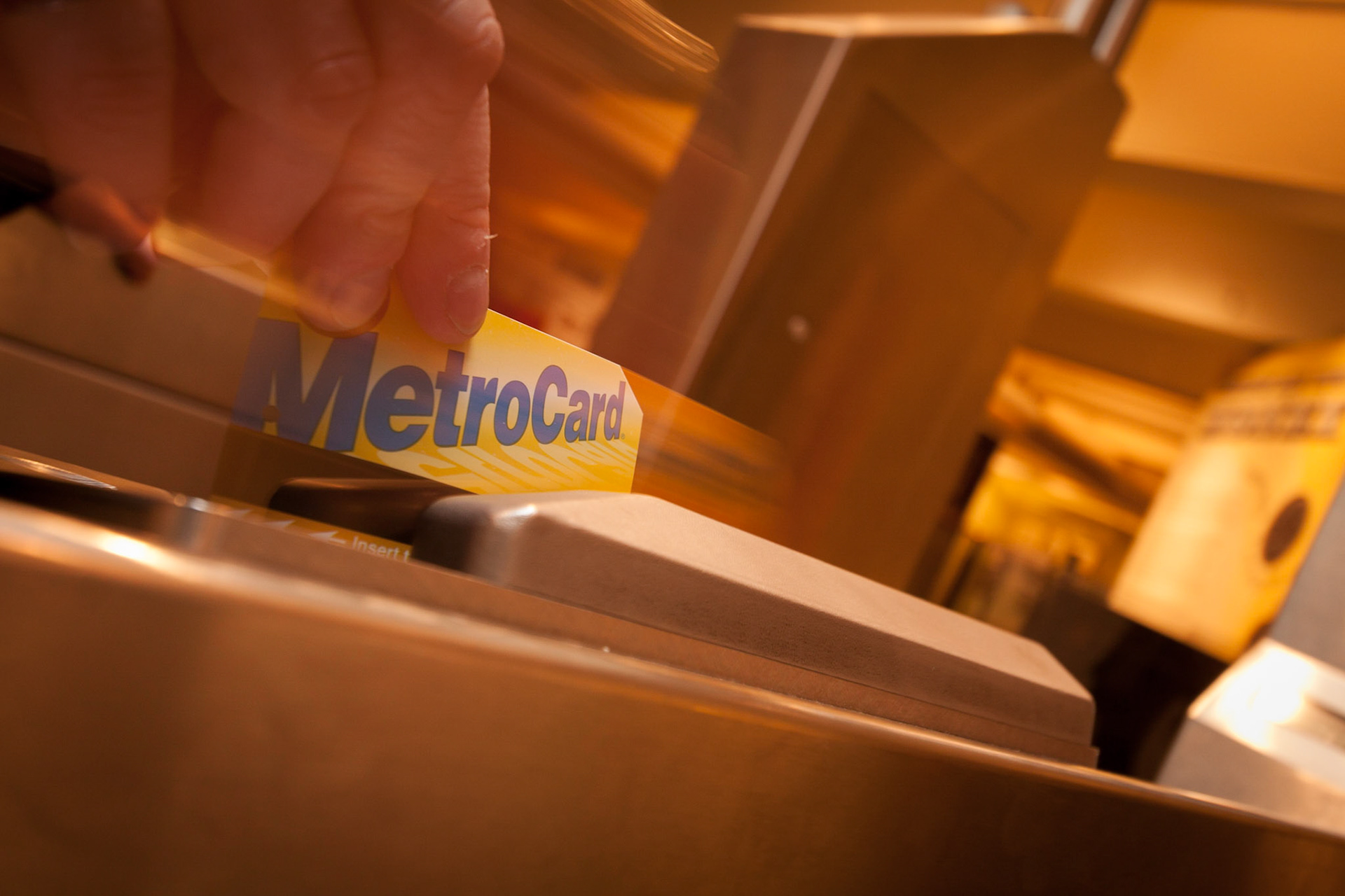 The picture of a Metrocard being swiped through a card reader at a subway entry gate. This image was taken at the Brooklyn Transit Museum.