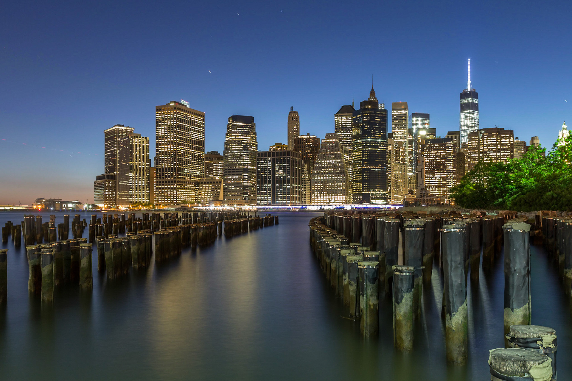 View over a polefield of an old pier towards the Downtown Manhattan Skyline