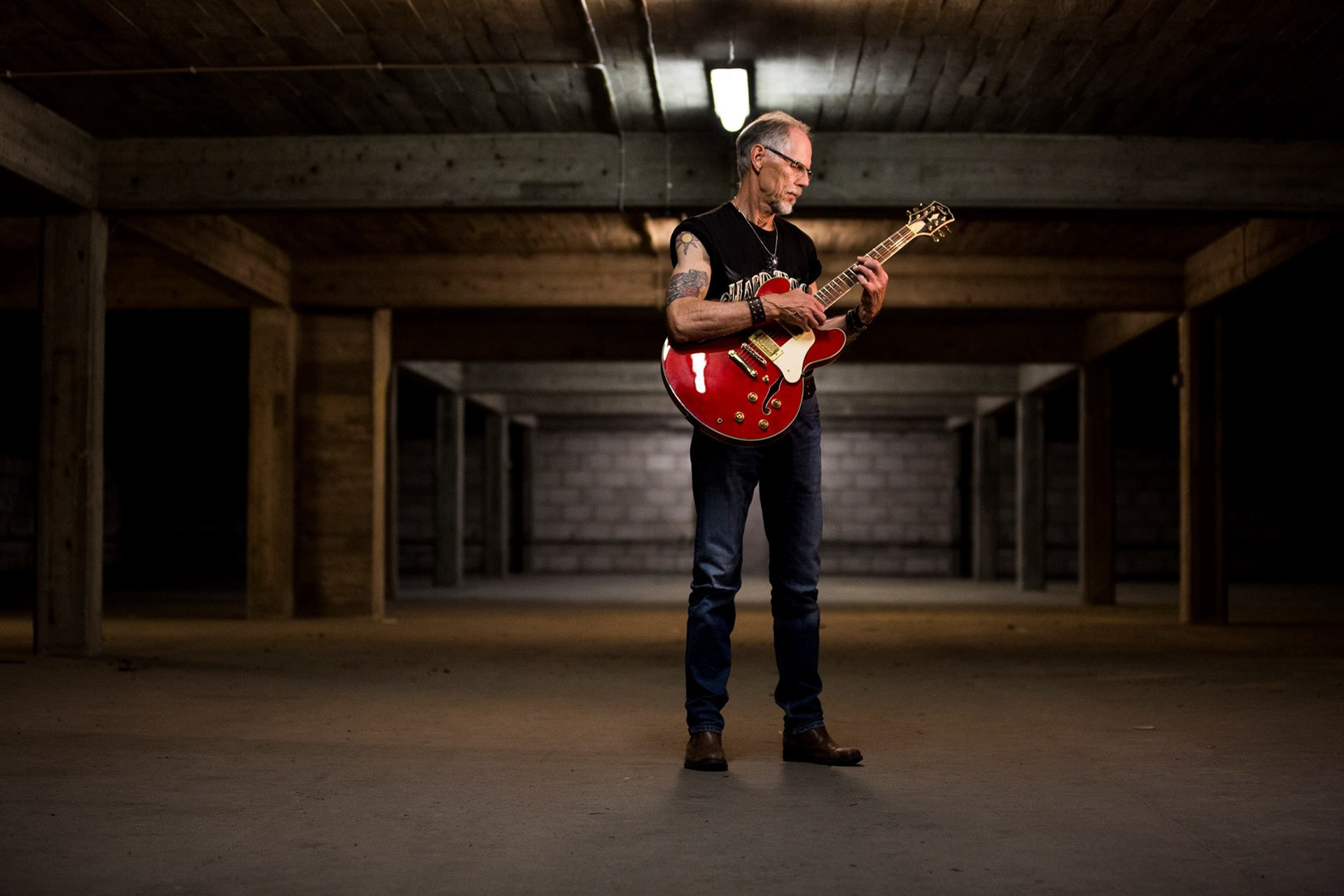 En äldre man spelar elgitarr