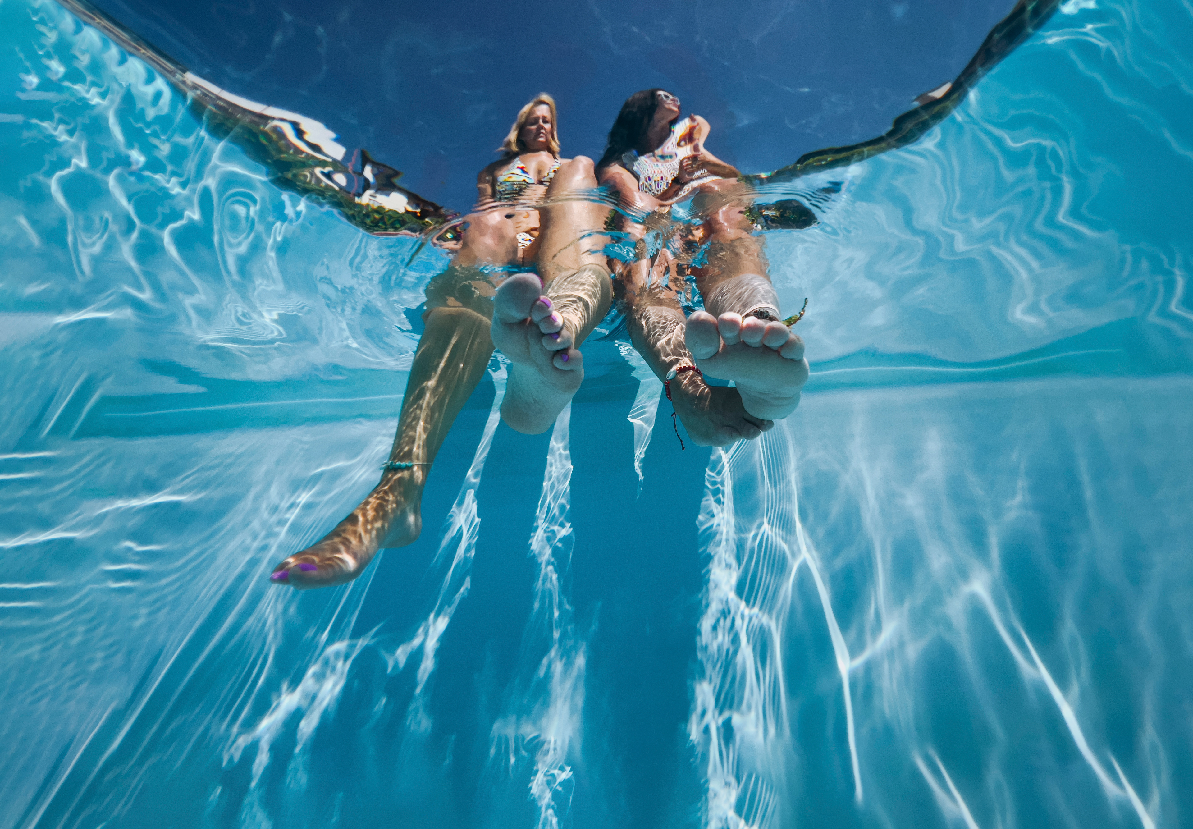 Two women relaxing at poolside — wellness, slow living, and real connection.  By Svetlana Iakusheva