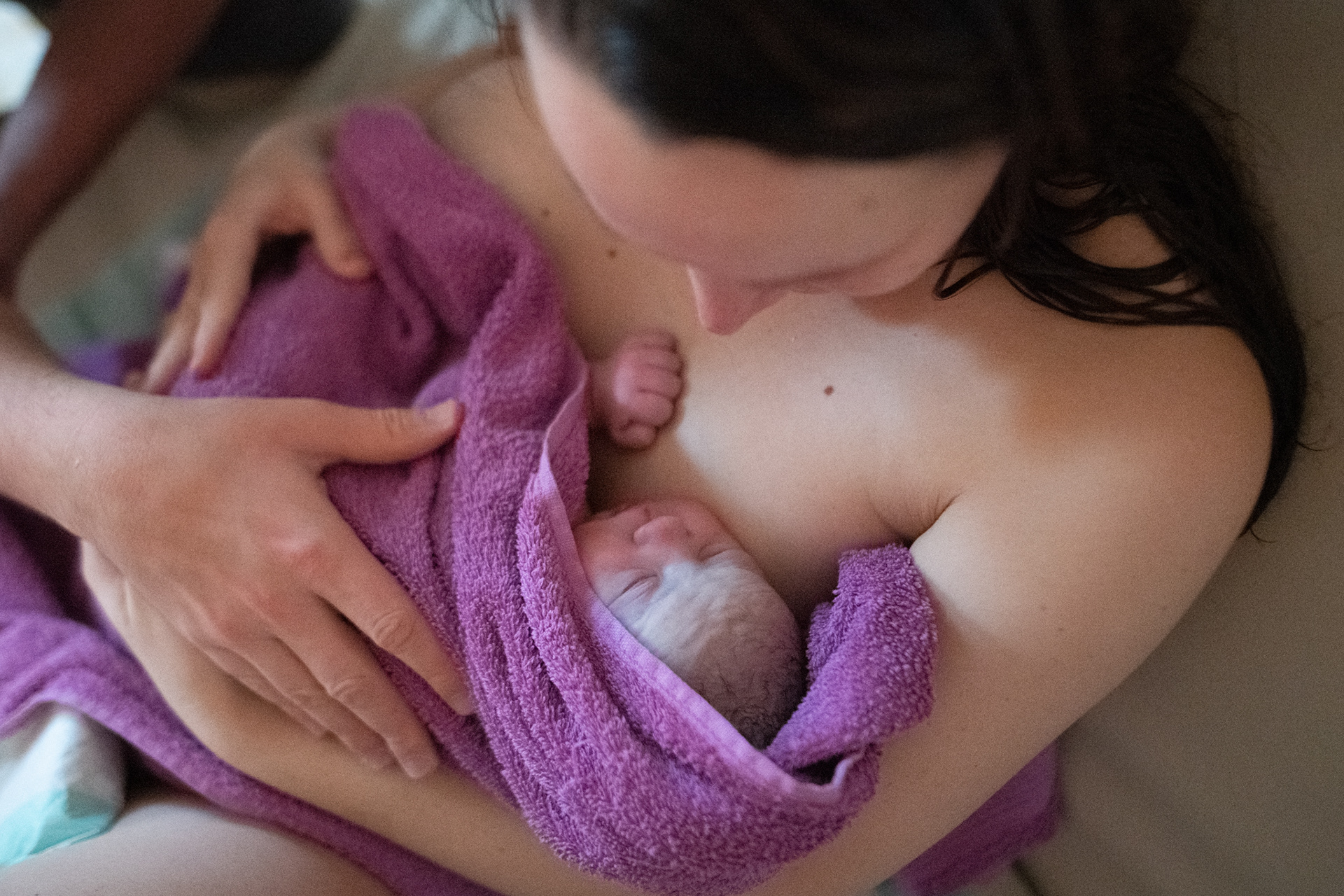 Mama hält Neugeborenes auf dem Arm
