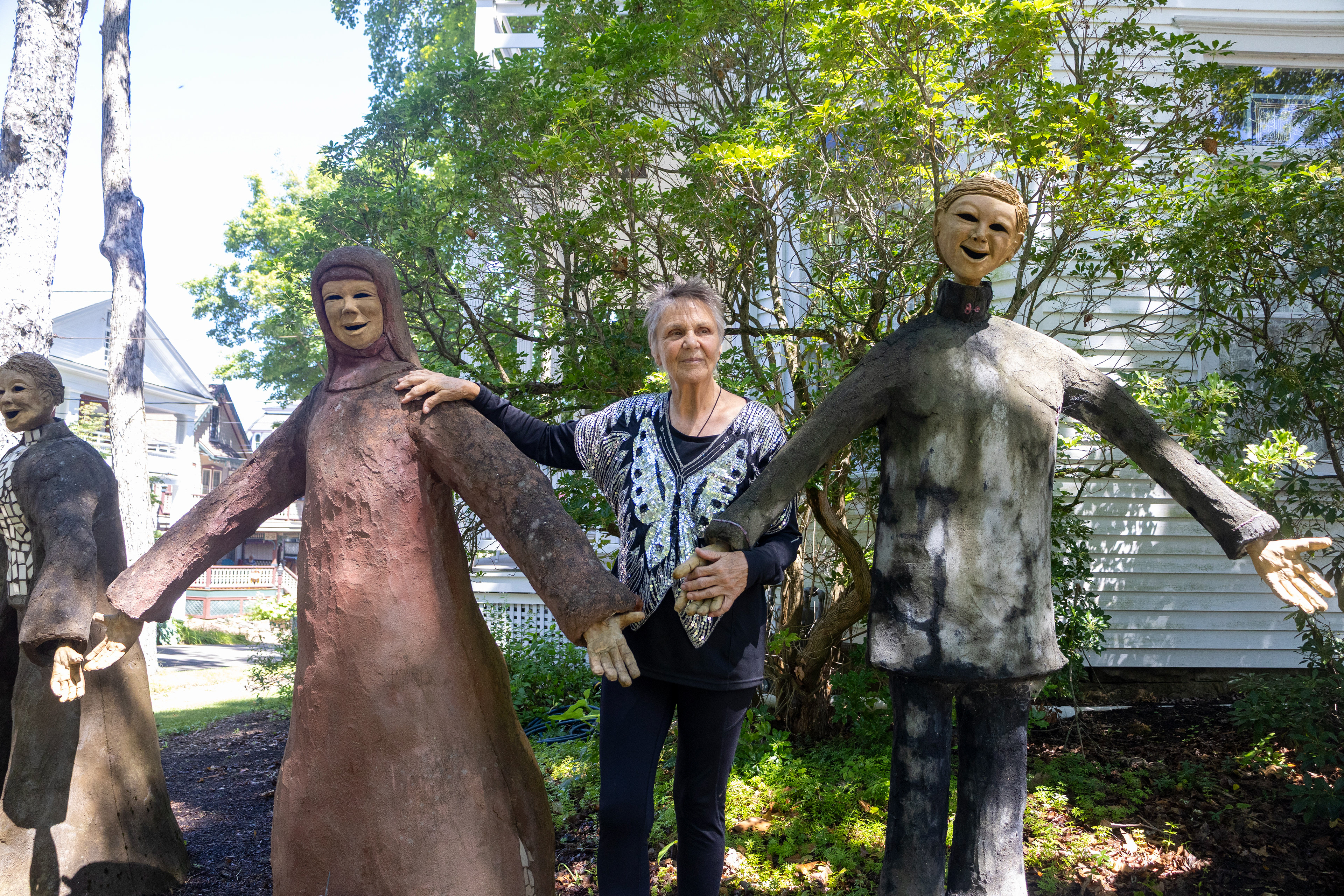 Artist Kirsten Engstrom stands next to her sculptures, “Aamenah,” meaning Lady of Peace and Harmony, and “Mirembe,” meaning peace, Aug. 4 outside the Baptist House.