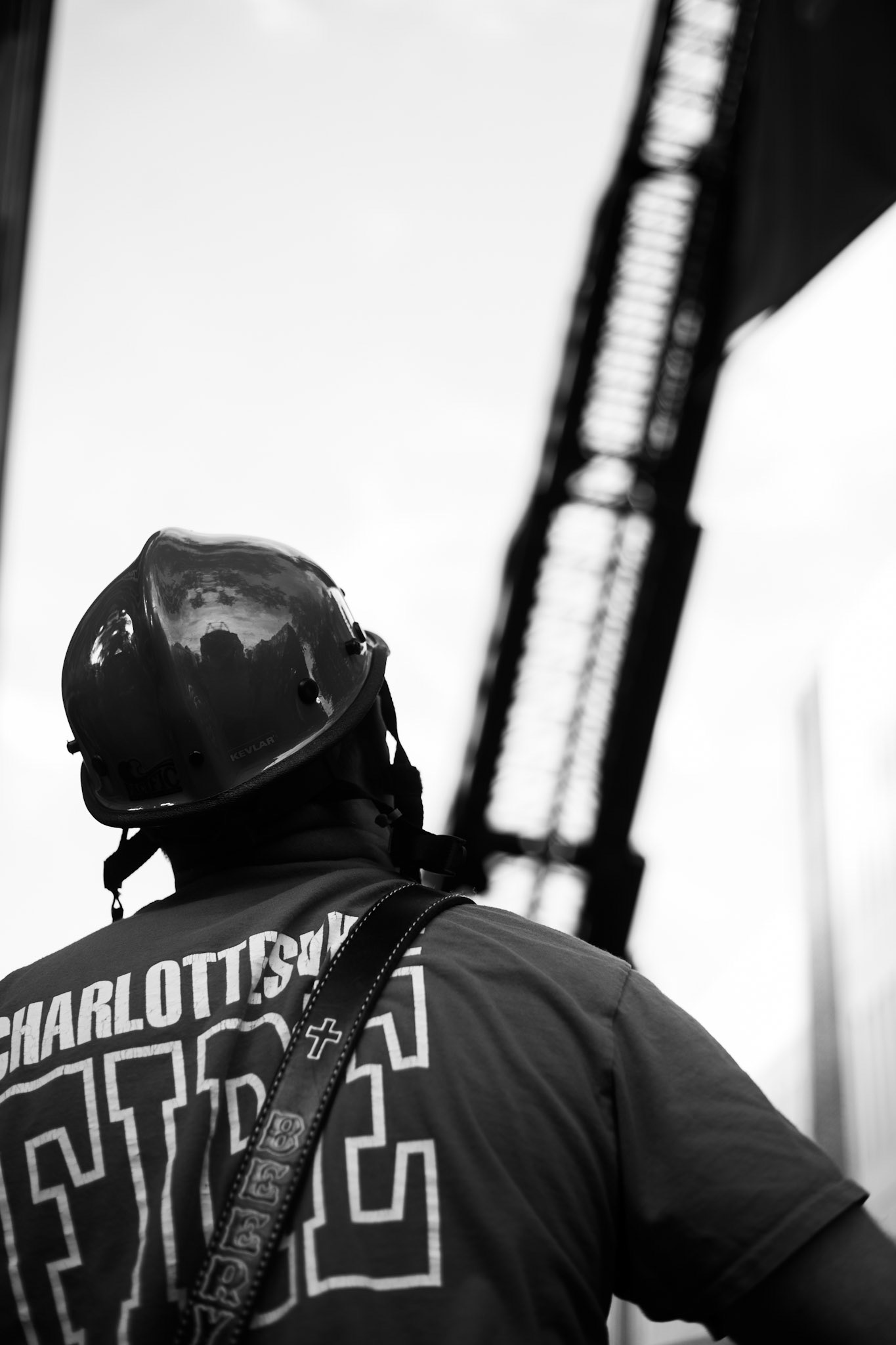 A Charlottesville fire department firefighter looks up toward the ladder of one their trucks.