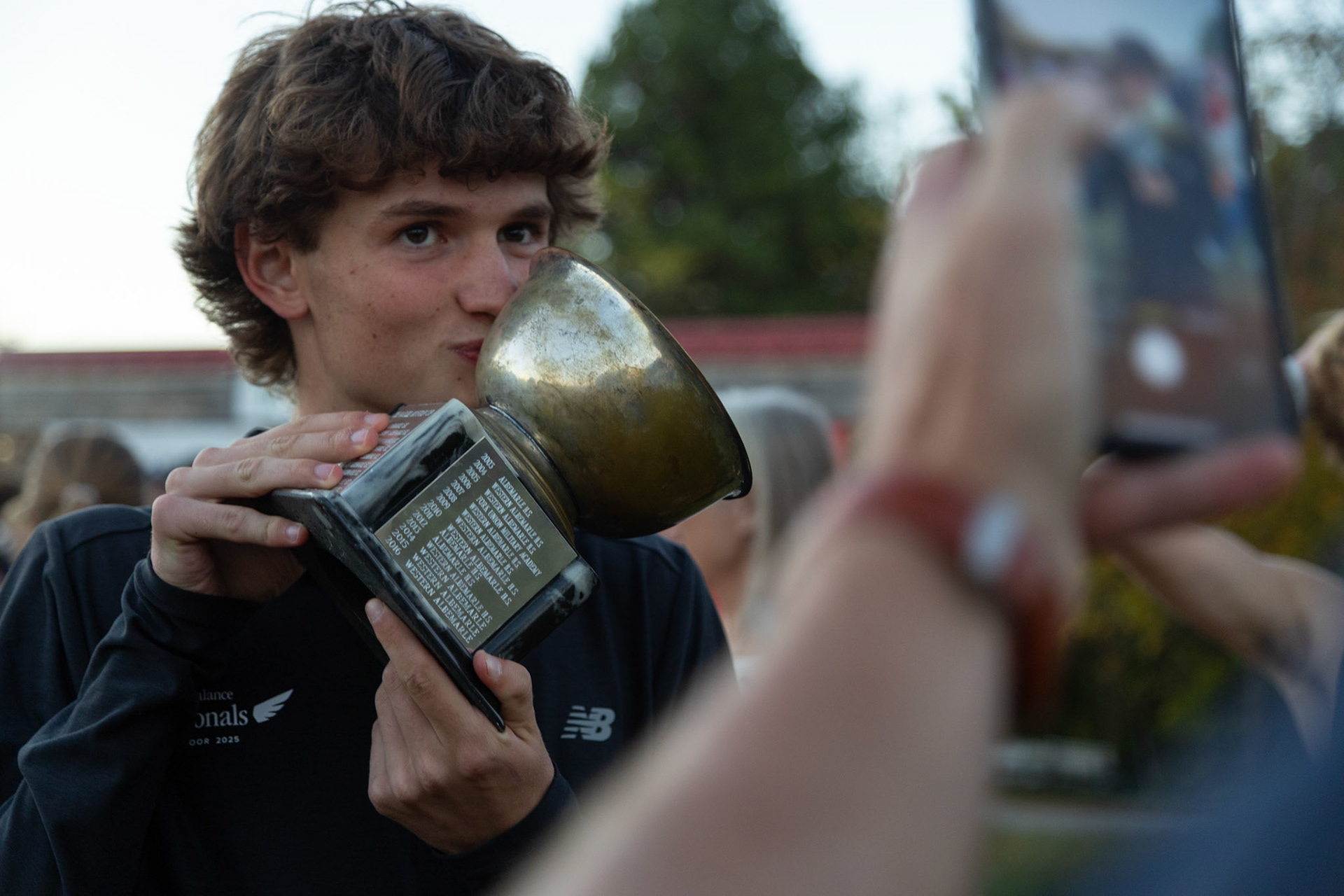 Graham Goodale kisses the Ragged Mountain Cup after Charlottesville High School won the annual relay competiton. October 14, 2025.