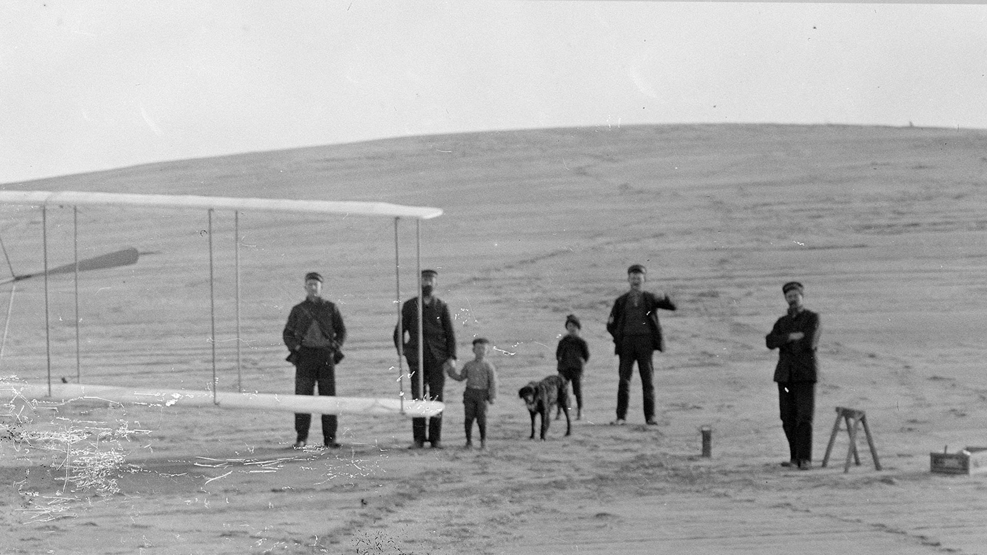 1903 Flyer on Big Kill Devil Hill, prior to December 14, 1903 trial. Lifesaving Station men helped move it, accompanied by two boys and dog.