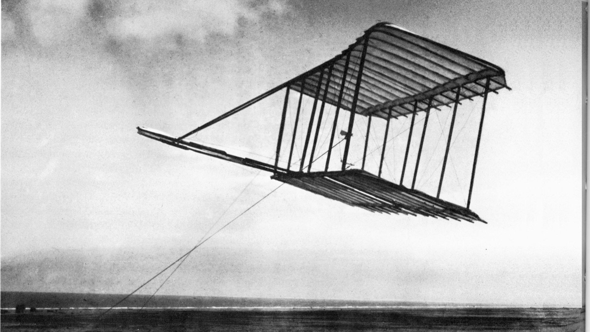 Left side view of Wright 1900 glider flying as a kite, Kitty Hawk, North Carolina.