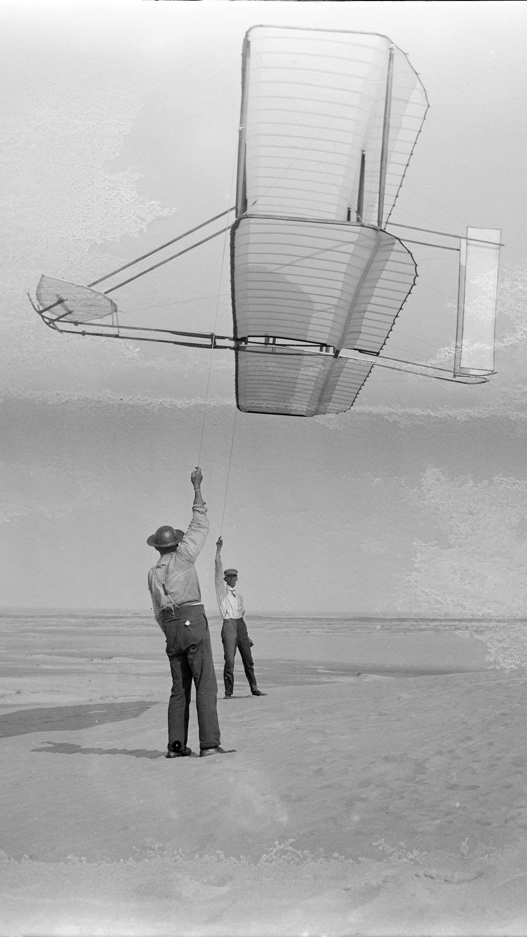 Dan Tate, left, and Wilbur, right, flying 1902 Wright glider as a kite, Kitty Hawk, North Carolina.