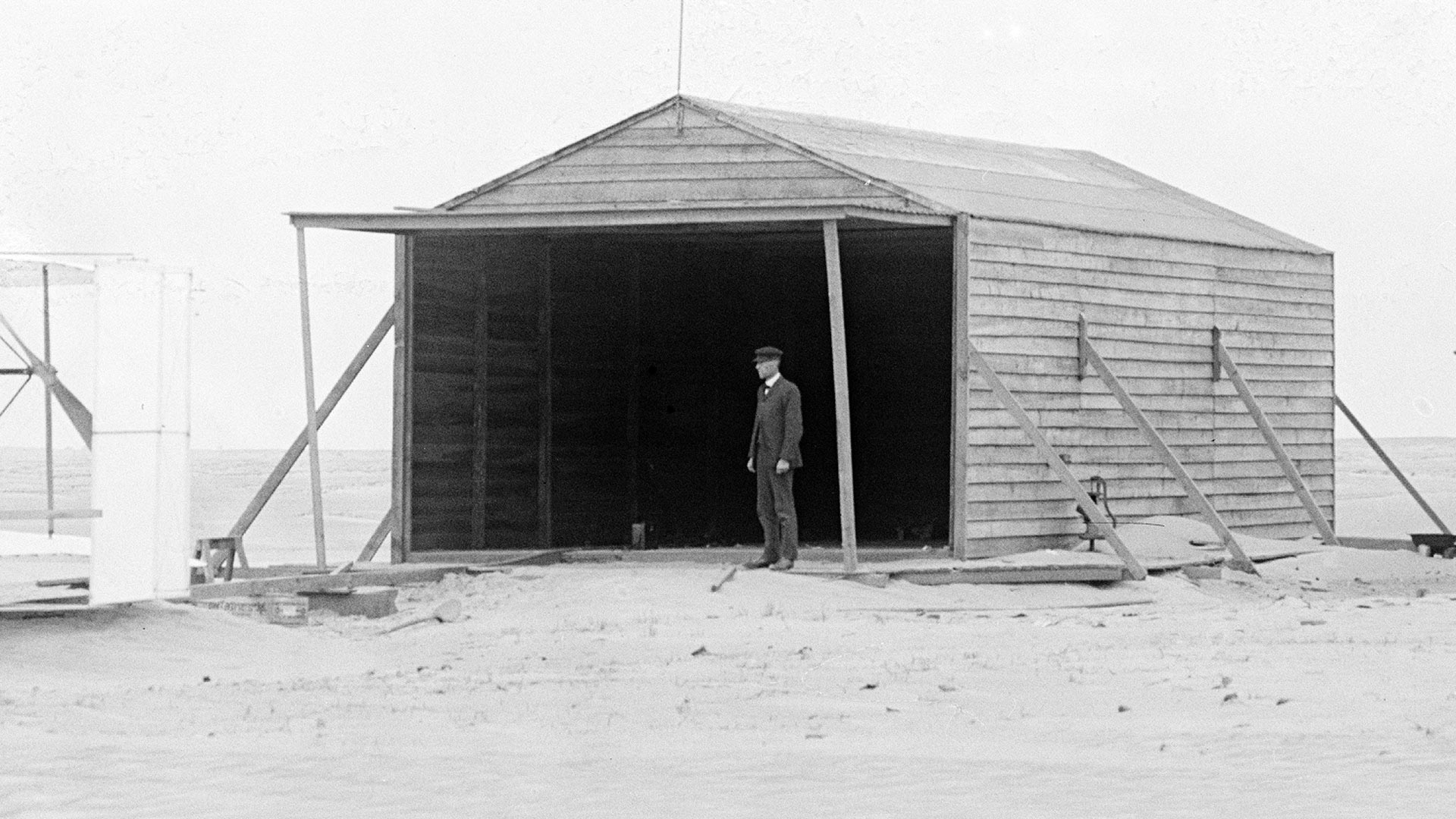 Wilbur Wright next to camp building on November 24, 1903, Kitty Hawk, North Carolina.