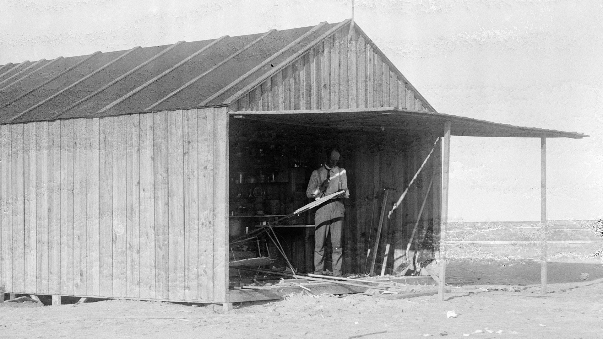 Wilbur Wright working on 1902 glider in camp building near Kitty Hawk, North Carolina.