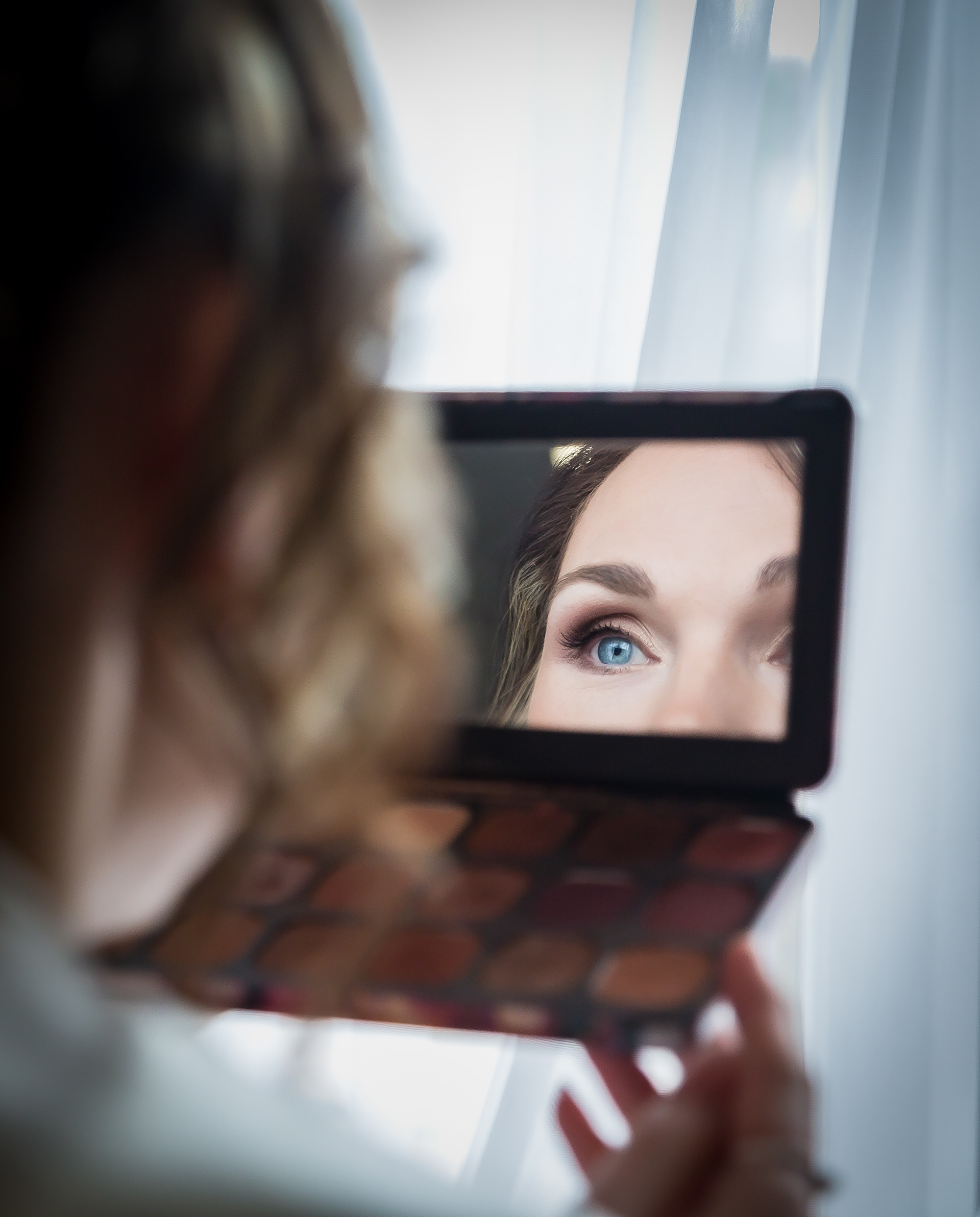 Bride looking into make up mirror y The Multi Media Market Wedding Photography in Dudley.