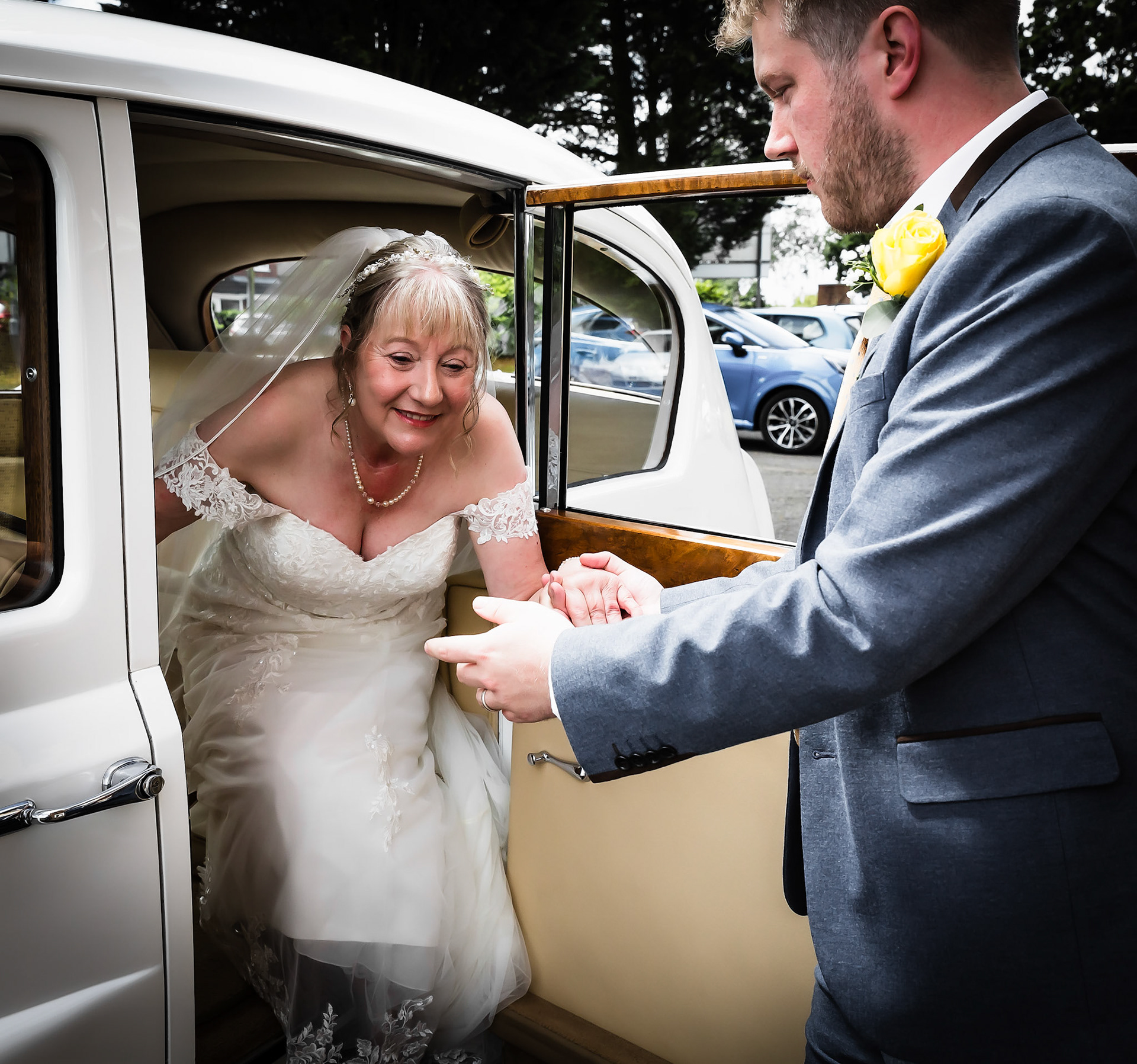 Bride getting out of wedding car by Wedding Photographer in Dudley