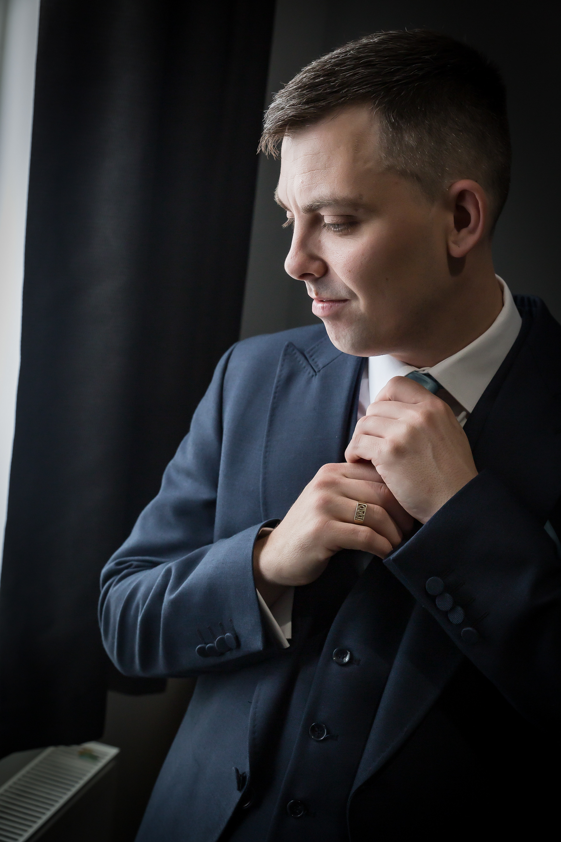 Groom adjusting his tie by The Multi Media Market Wedding Photography in Dudley.