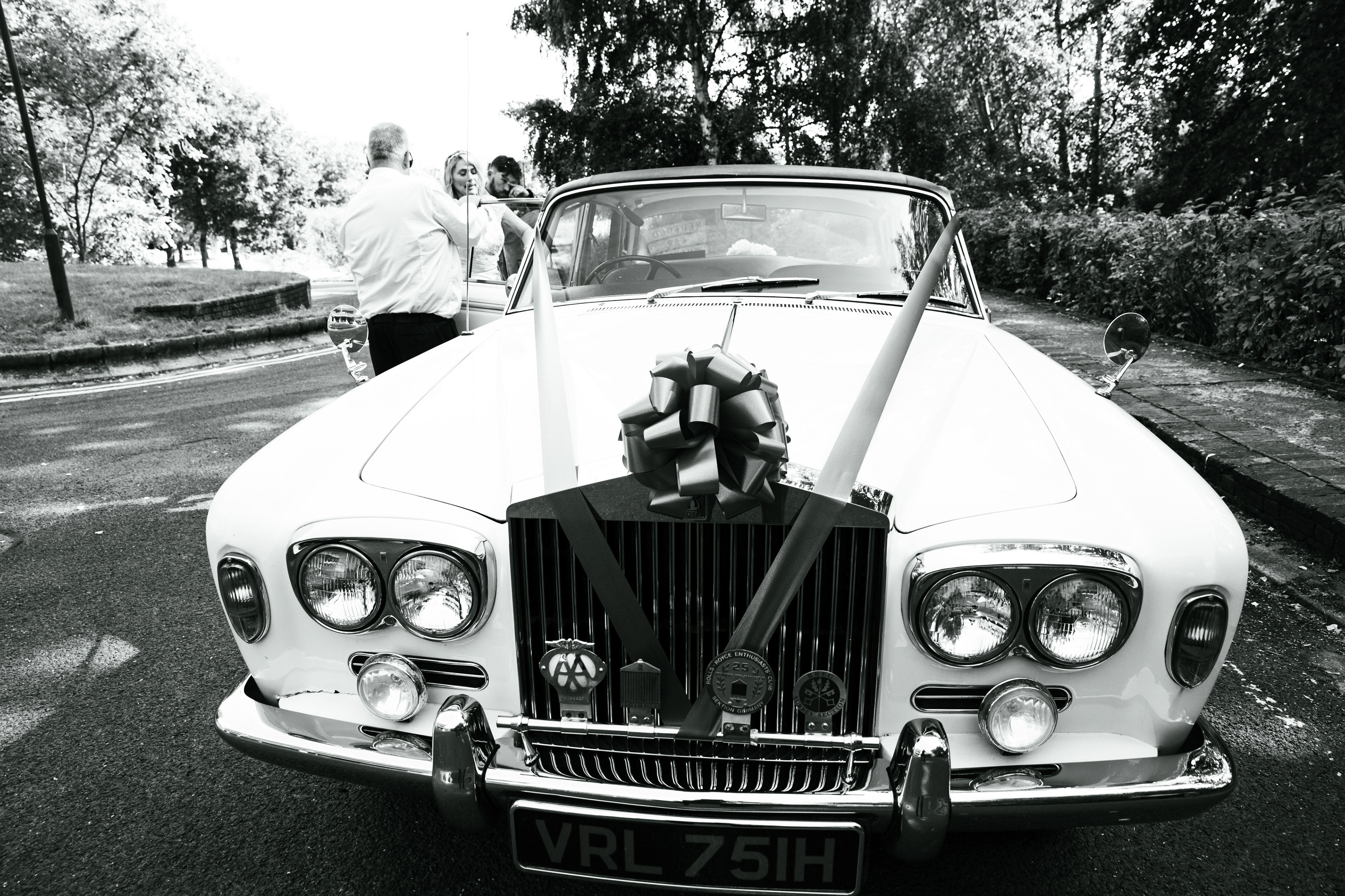 Bride and groom with car