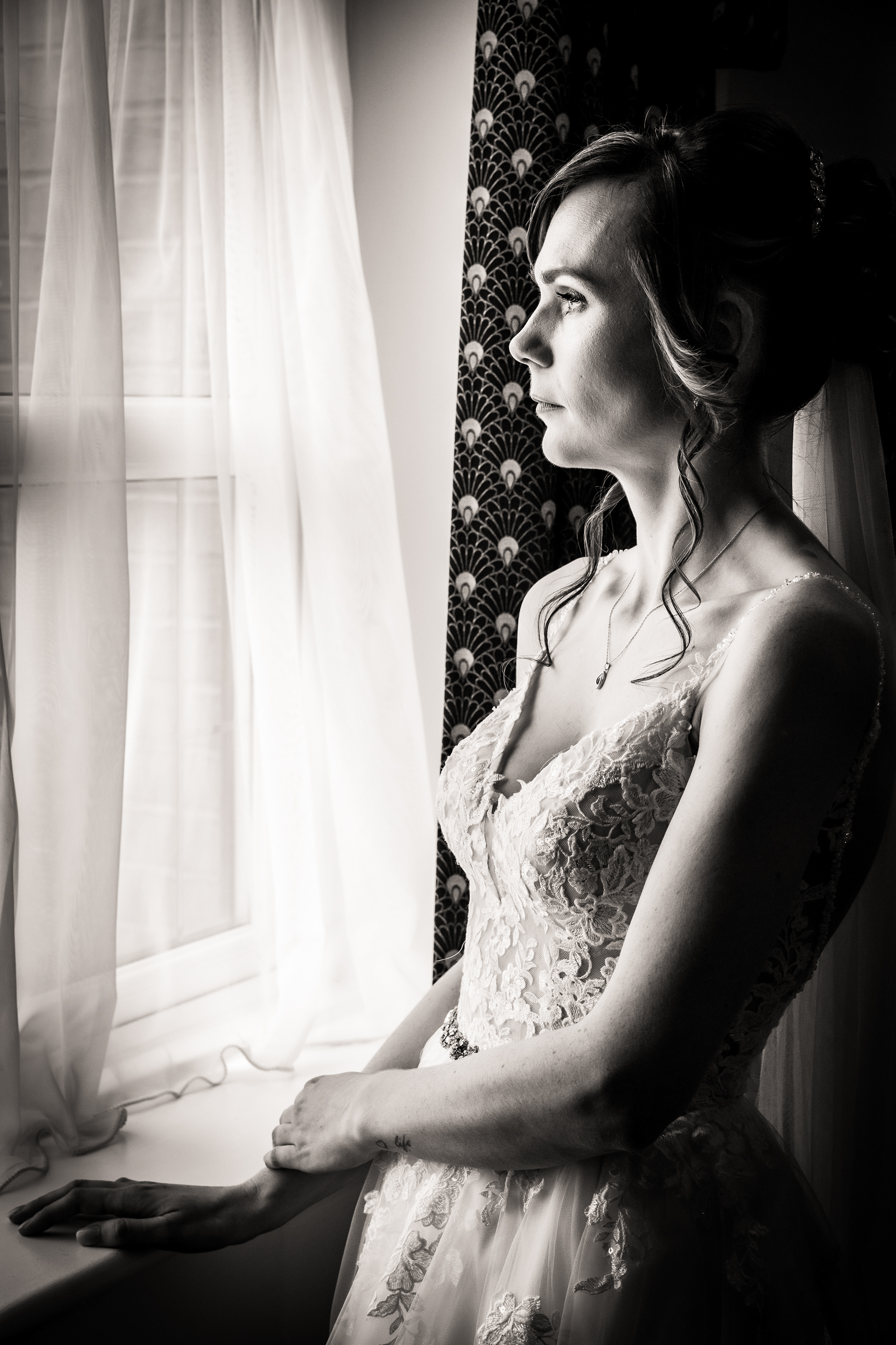 Bride looking out of window by The Multi Media Market Wedding Photography in Dudley.