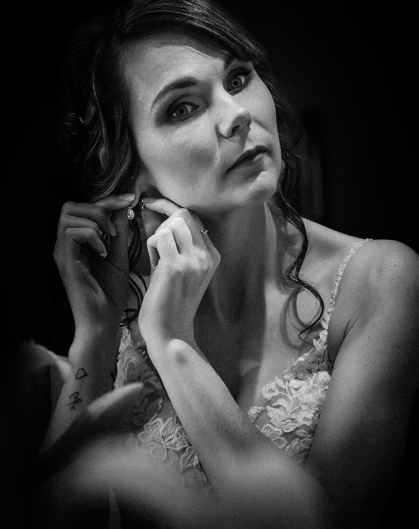 Bride putting on earings by Wedding Photographer in Dudley