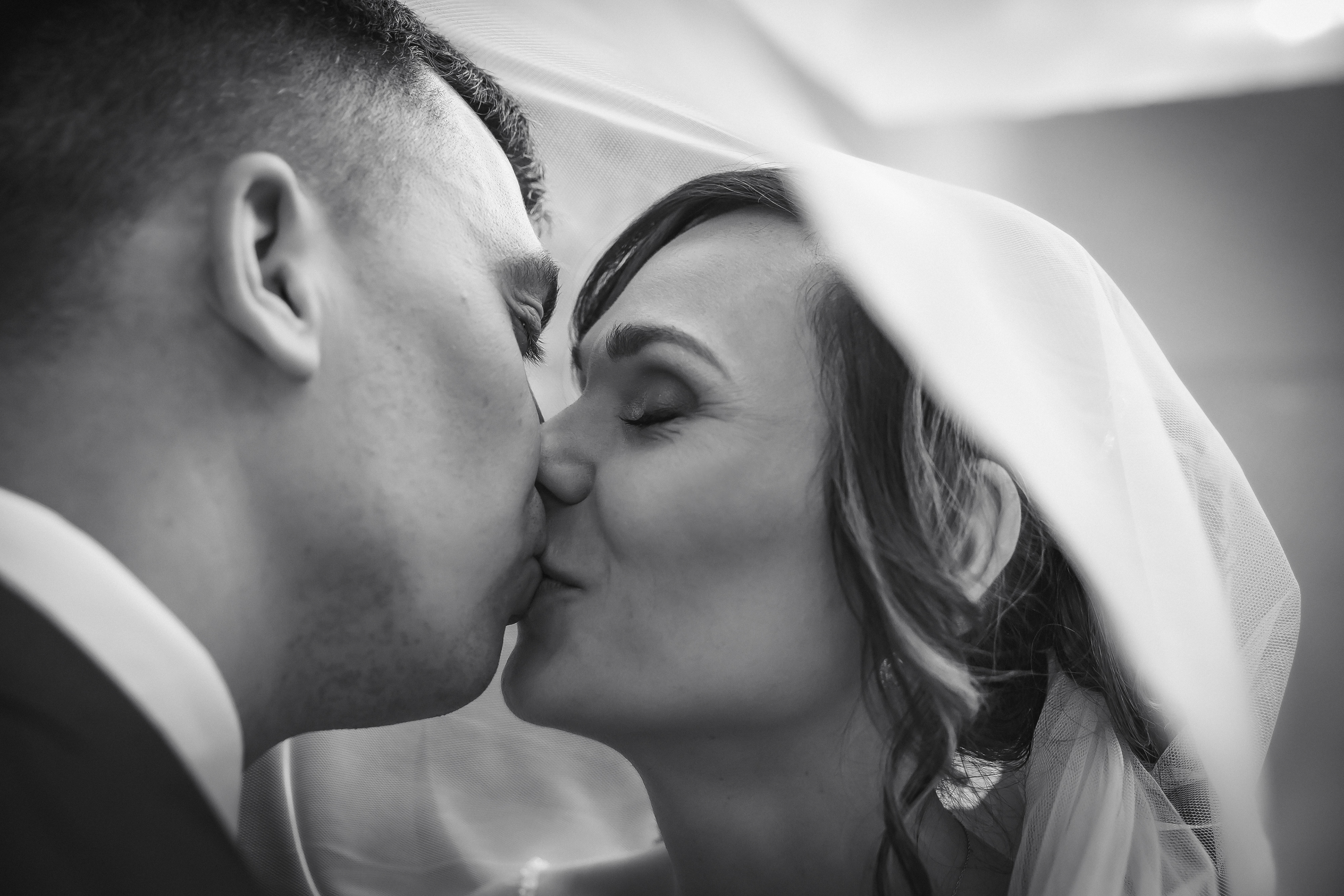 Kissing under the veil by The Multi Media Market Wedding Photography in Dudley.