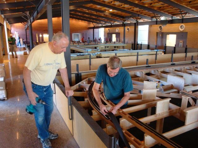 Russ Mosser adds new roadbed foam as Paul Boston assists.