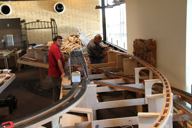 Wesley is holding the layout down so Bob can work on it more easily.