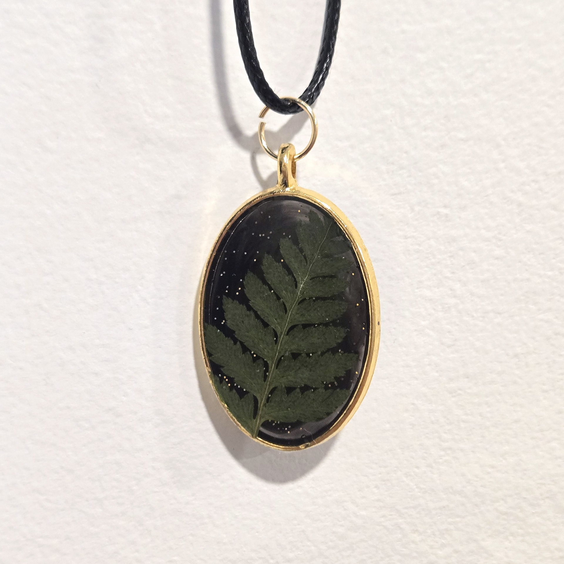 19. leaf stem in black glitter oval, gold frame