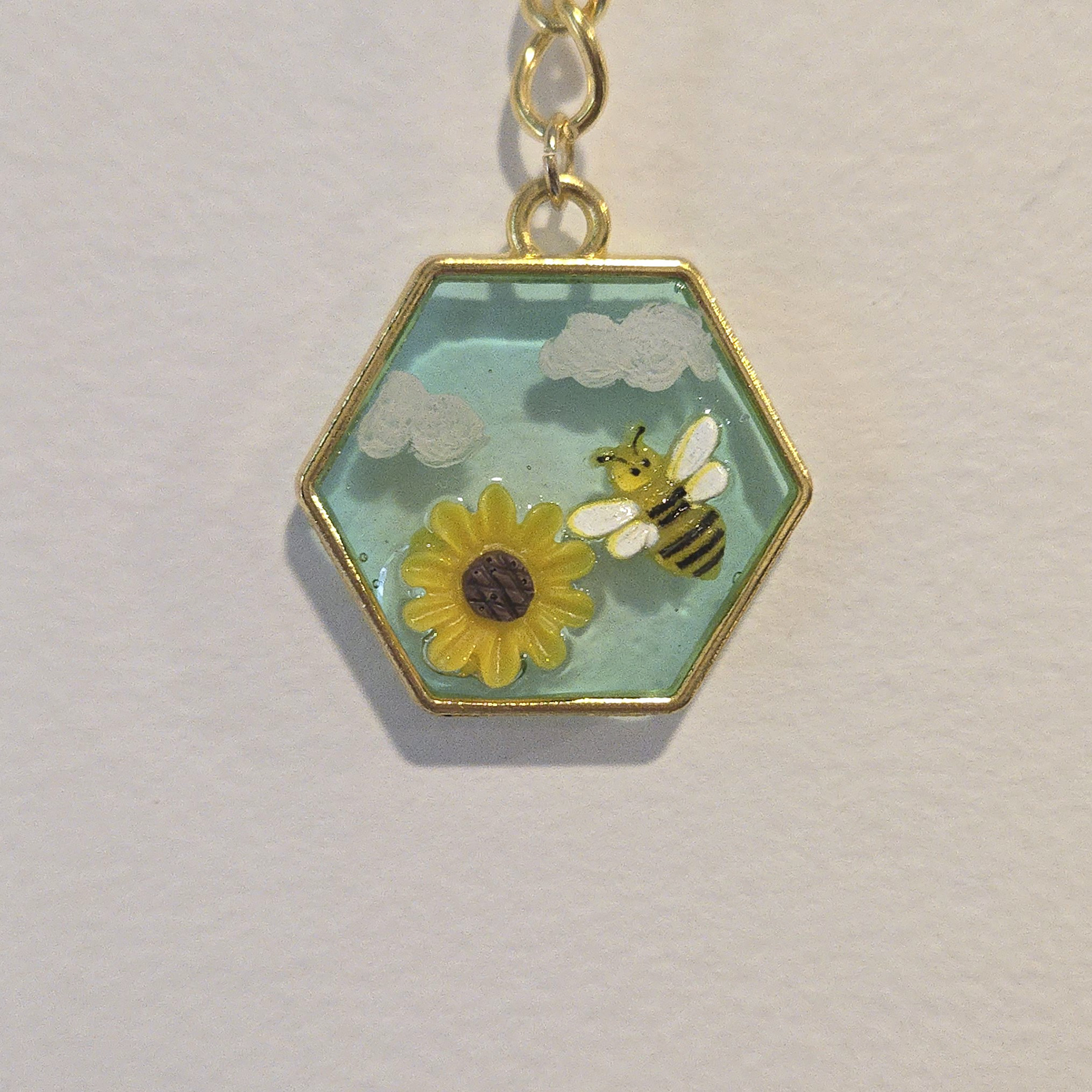 32. busybee and flower charm in light blue hexagon, gold frame