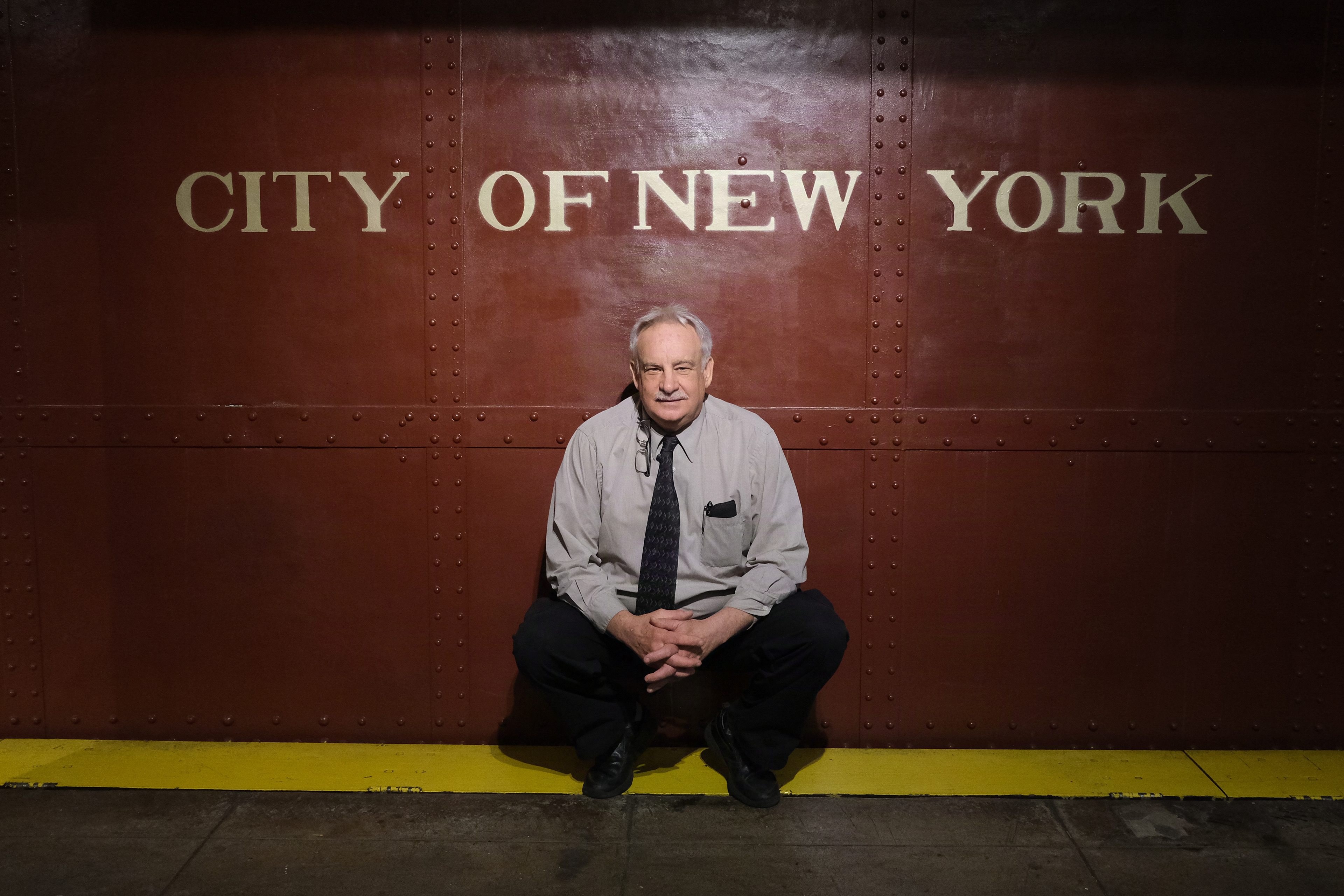 Retired MTA repairman Bill Allcot poses in front of an antique train.