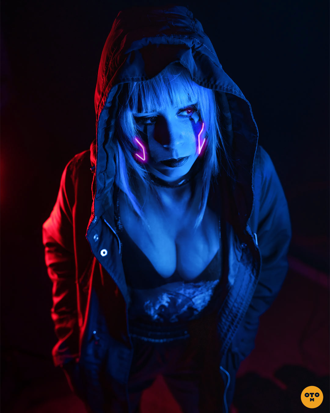 Blue cyborg girl with hands in pockets, wearing tech wear jacket, moody cyberpunk inspired photoshoot by photographer otrominuto, featuring emitela as model.