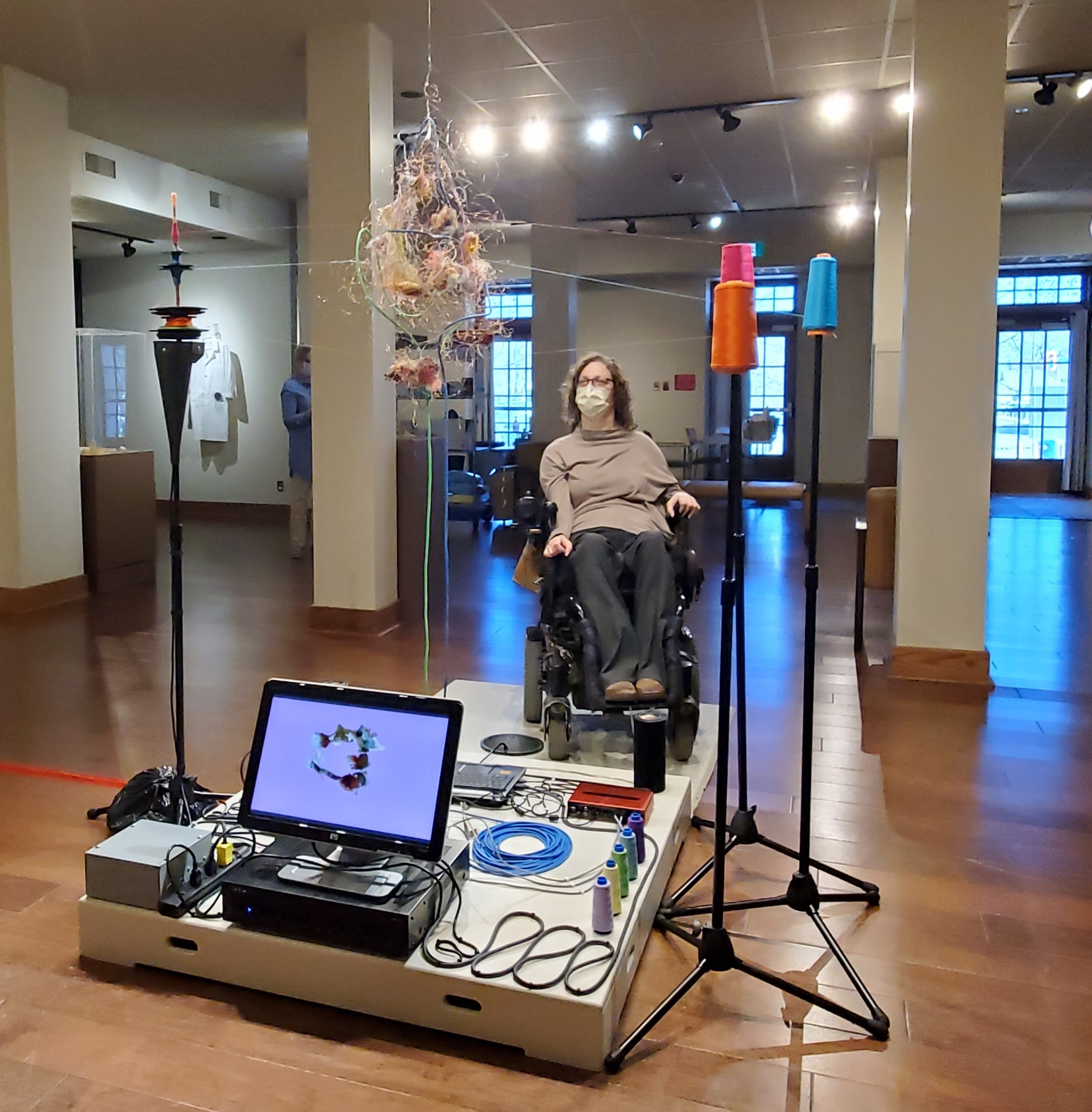 A woman in a powerchair engages with an artwork