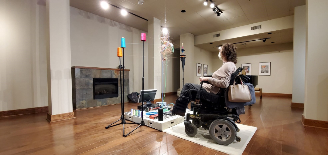 a woman in a power chair egages with art