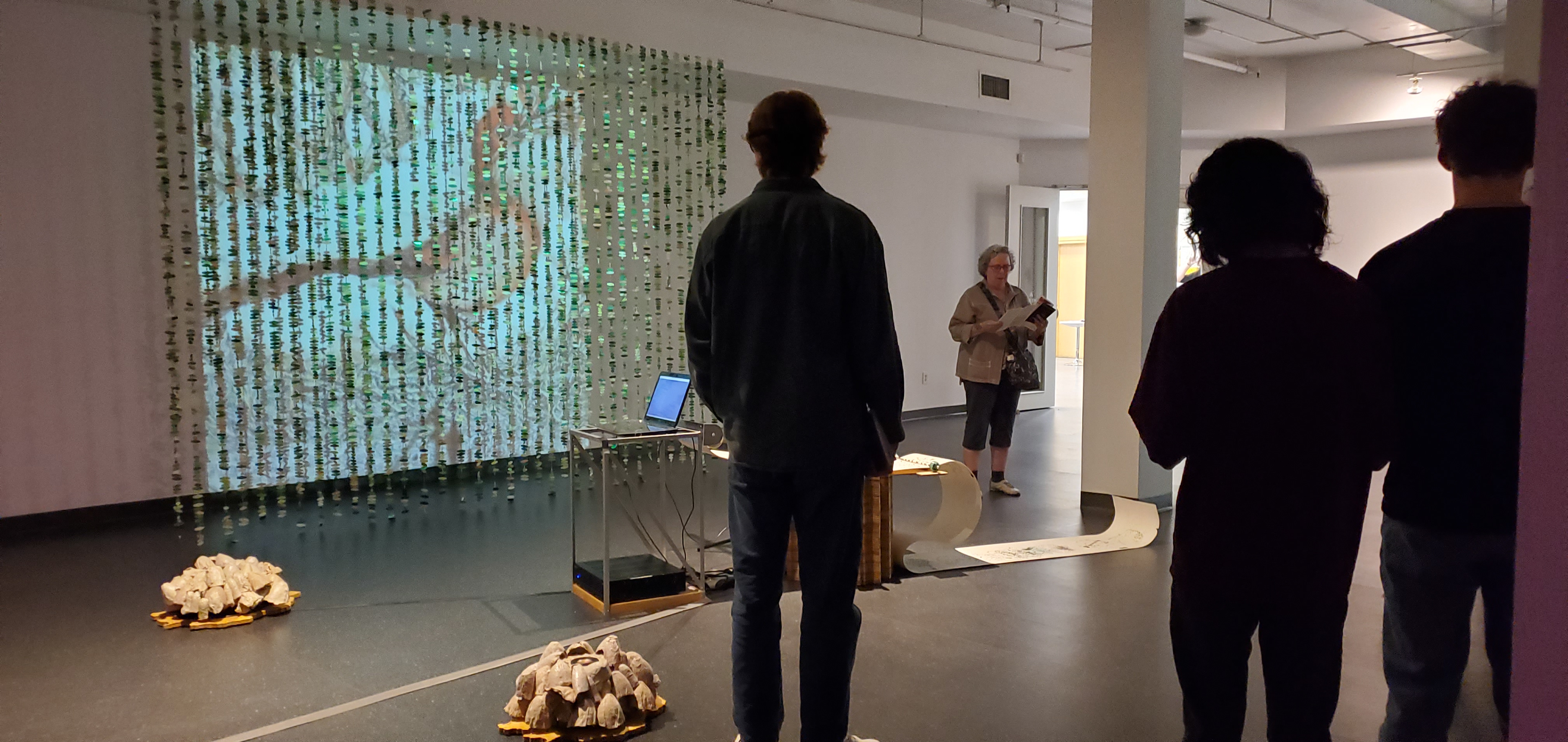 a group of people stand in an art gallery viewing an art installation