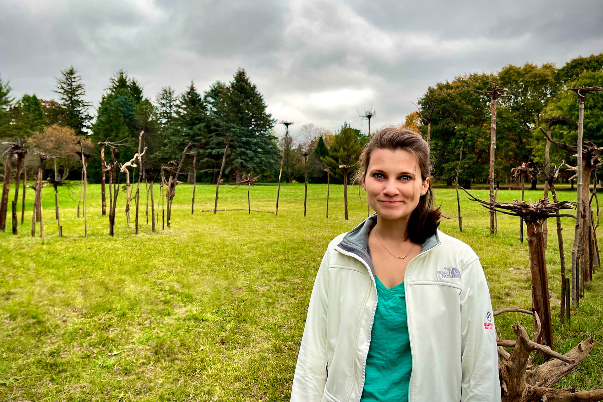Sinclair Myhre artist-in-recidence at Hawthorn Hollow in front of new Installation