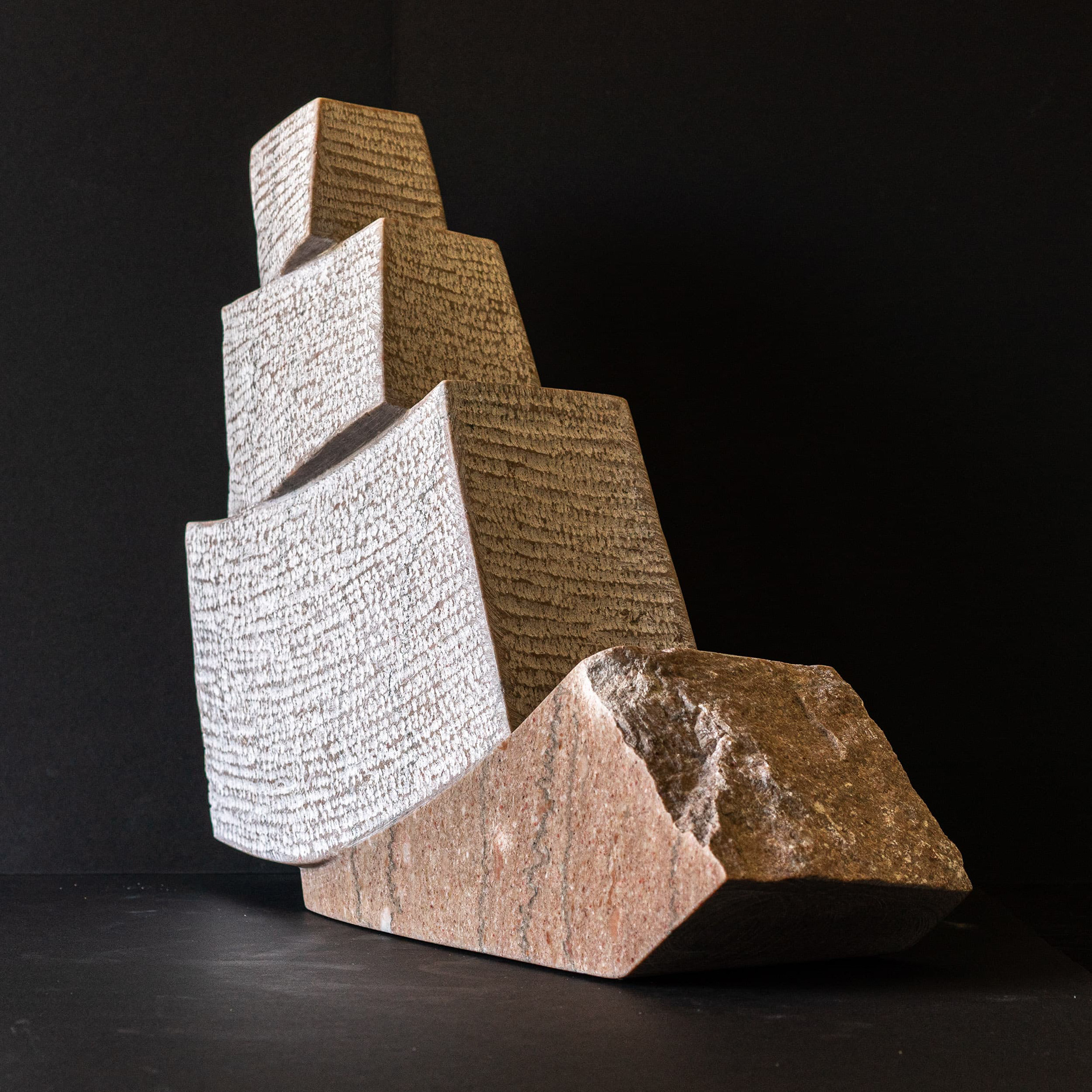 Backslide — marble sculpture by Cristian Ianculescu in Tennessee Pink Marble, shown in soft studio light highlighting vertical tension.