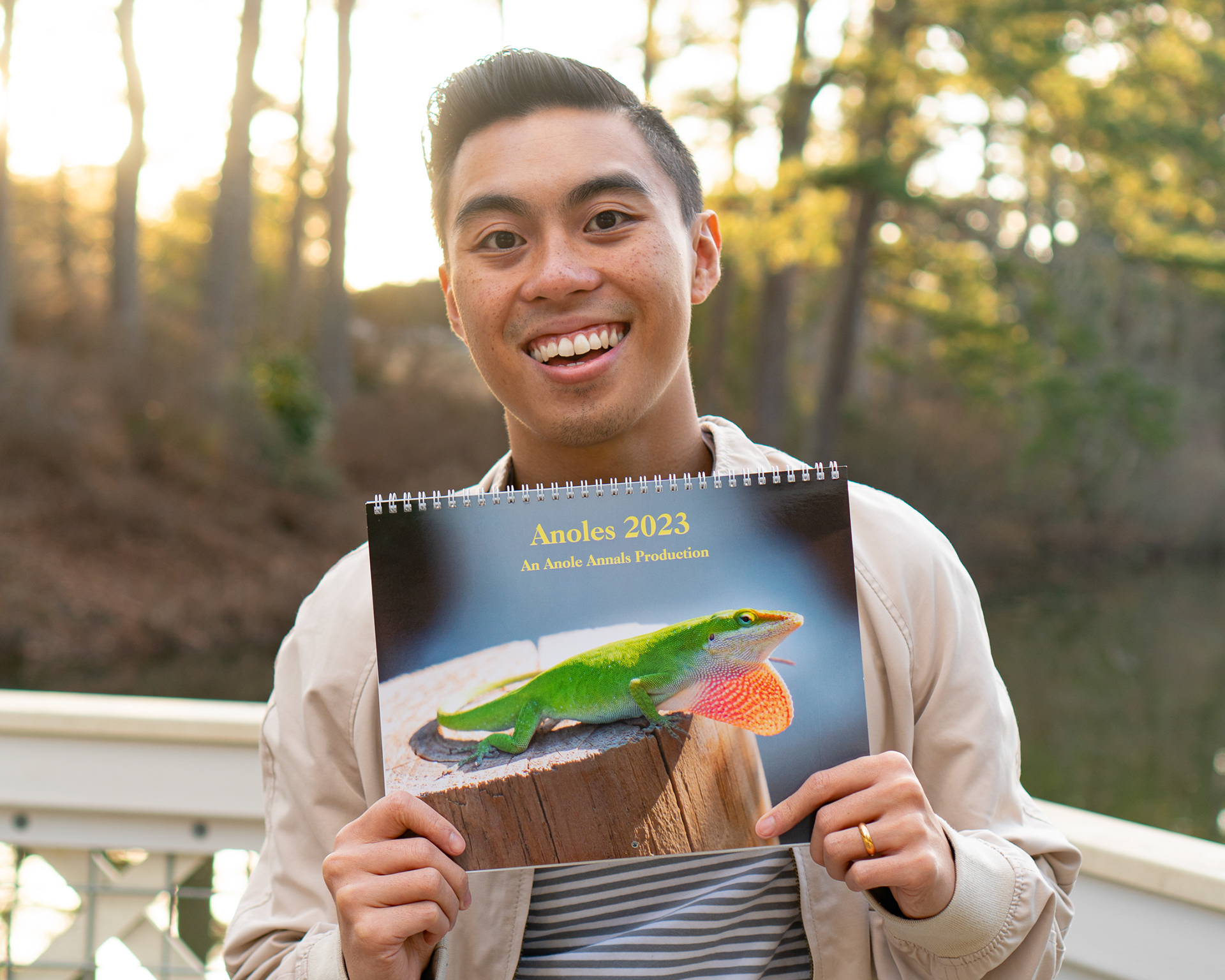 Aaron holding the Anole Annals 2023 Calendar.