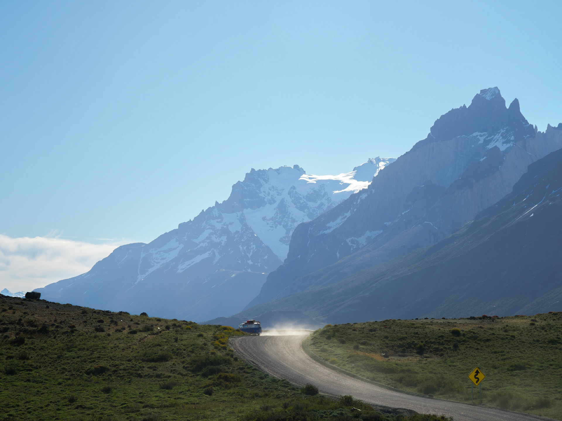 Blau-weißer Campingbulli und seine Staubwolke