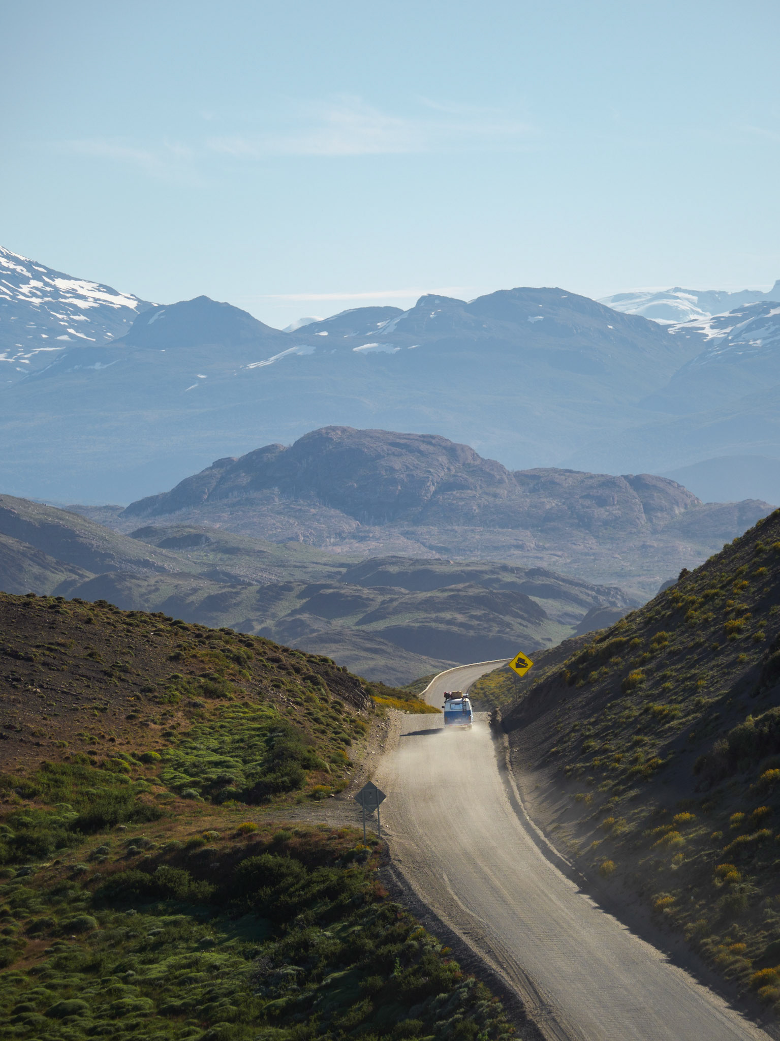 Blau-weißer Campingbulli und seine Staubwolke