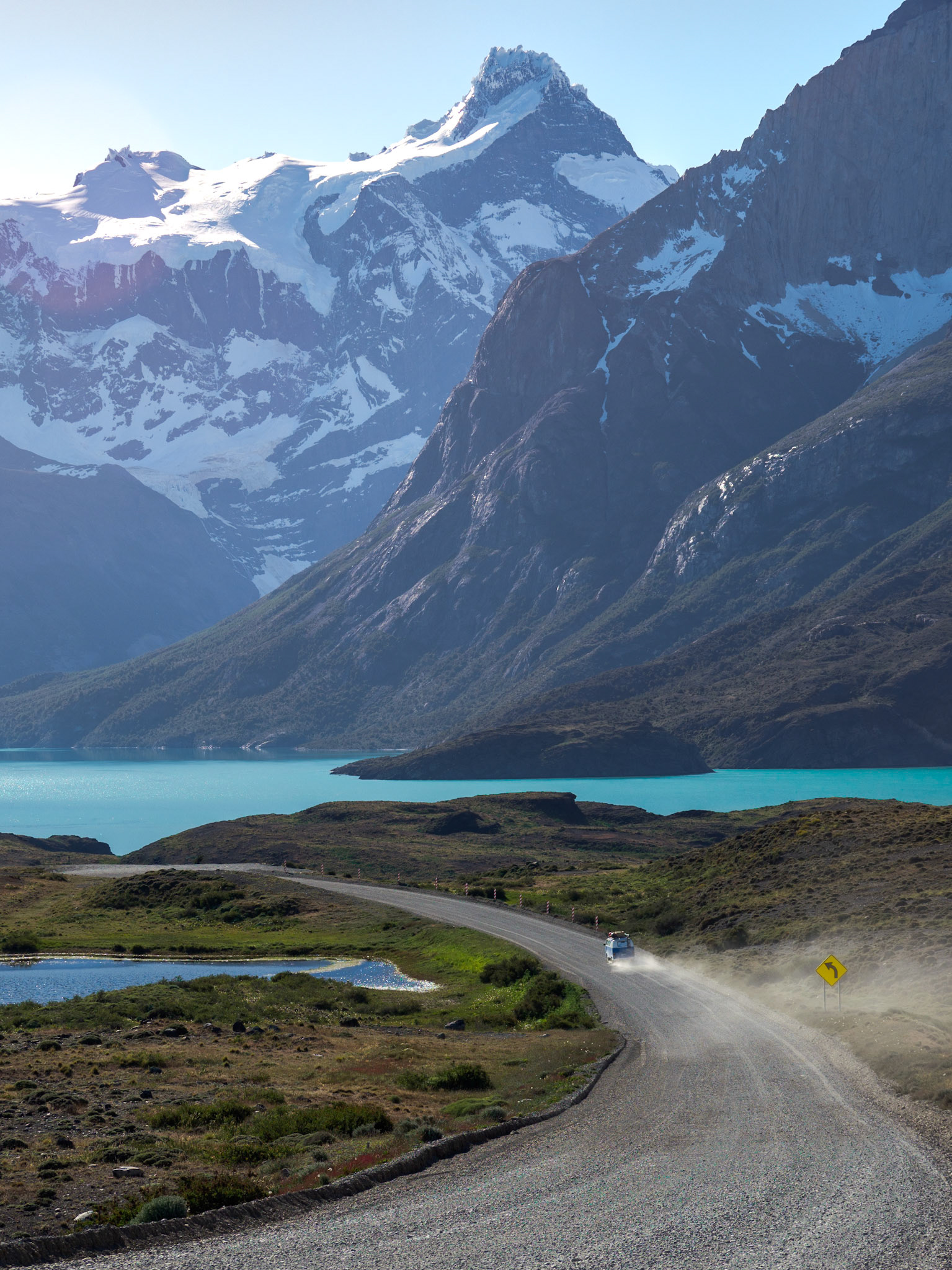 Blau-weißer Campingbulli und seine Staubwolke