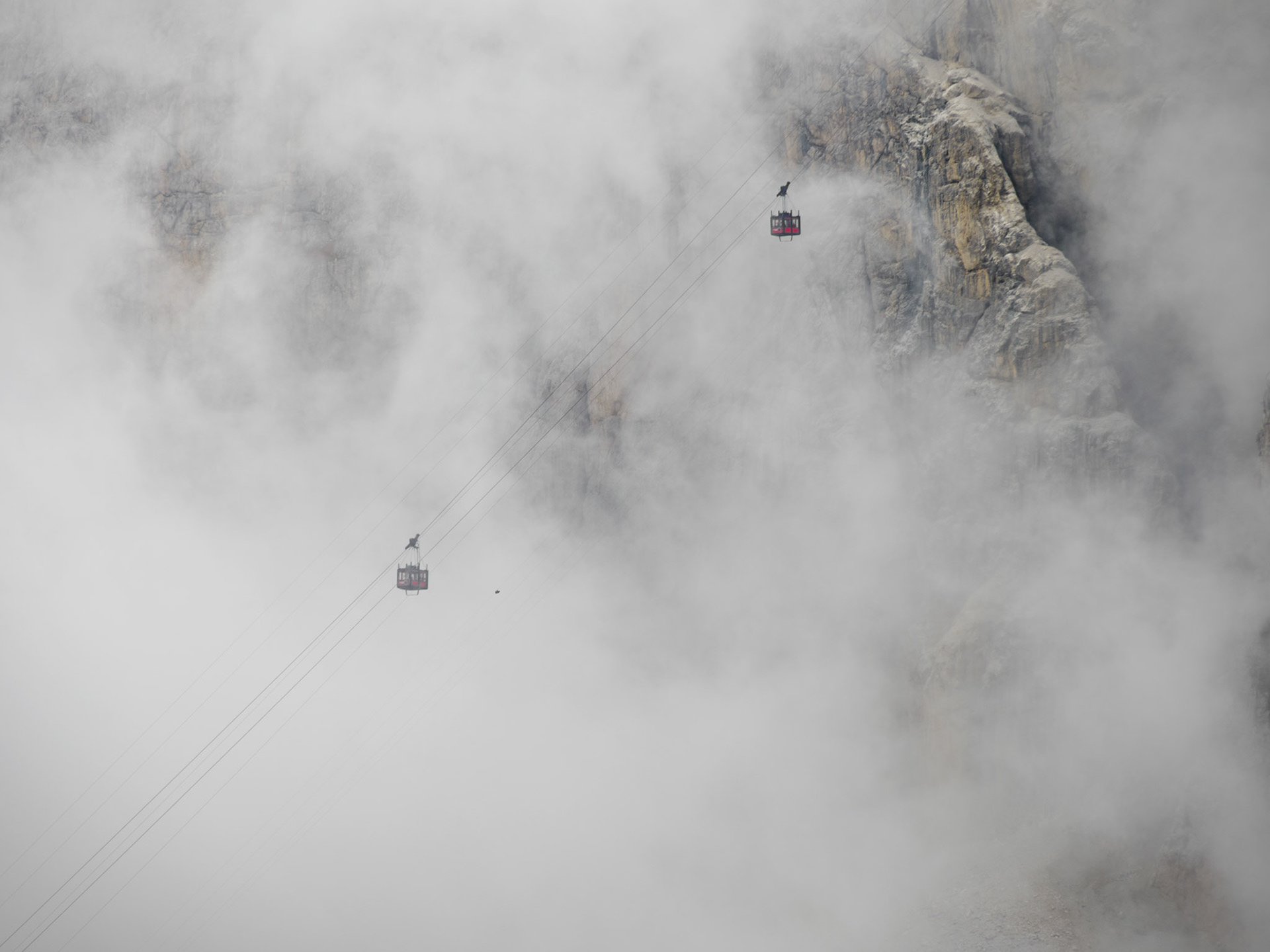 Gondeln der Lagazuoi-Seilbahn verschwinden im Nebel