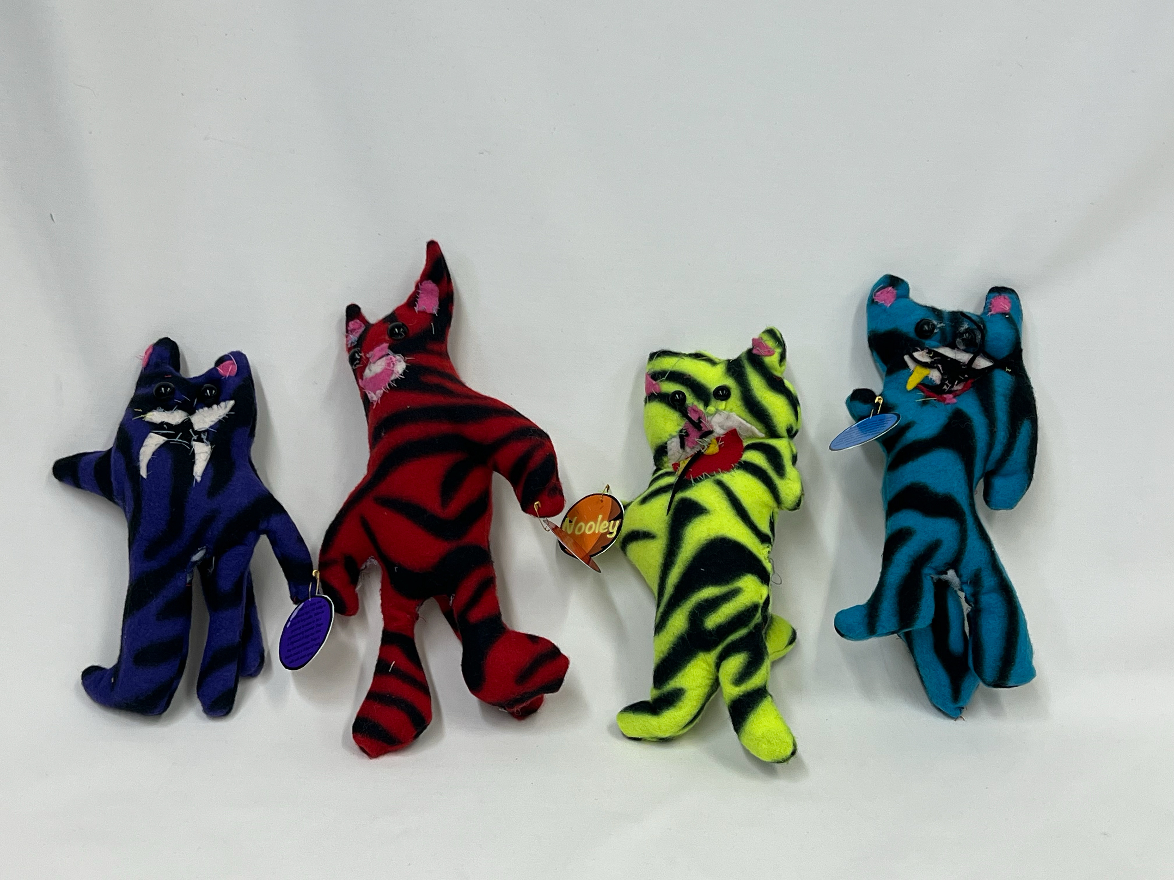 Four stuffed tigers each with name tags