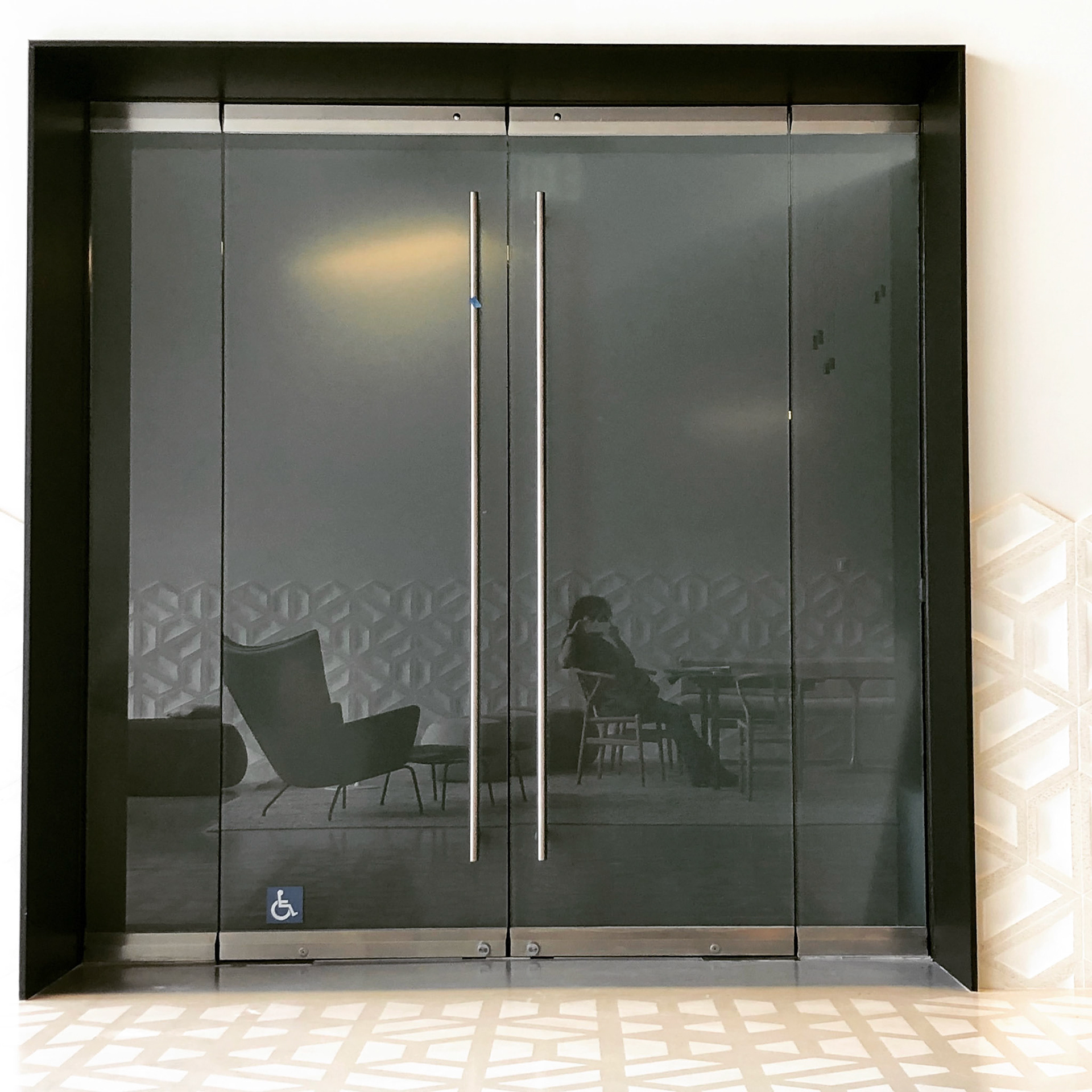 3/4" steel surrund painted and inserted into existing recess as means of defiing main tenant entry; glass door and sidelites remained in place.
