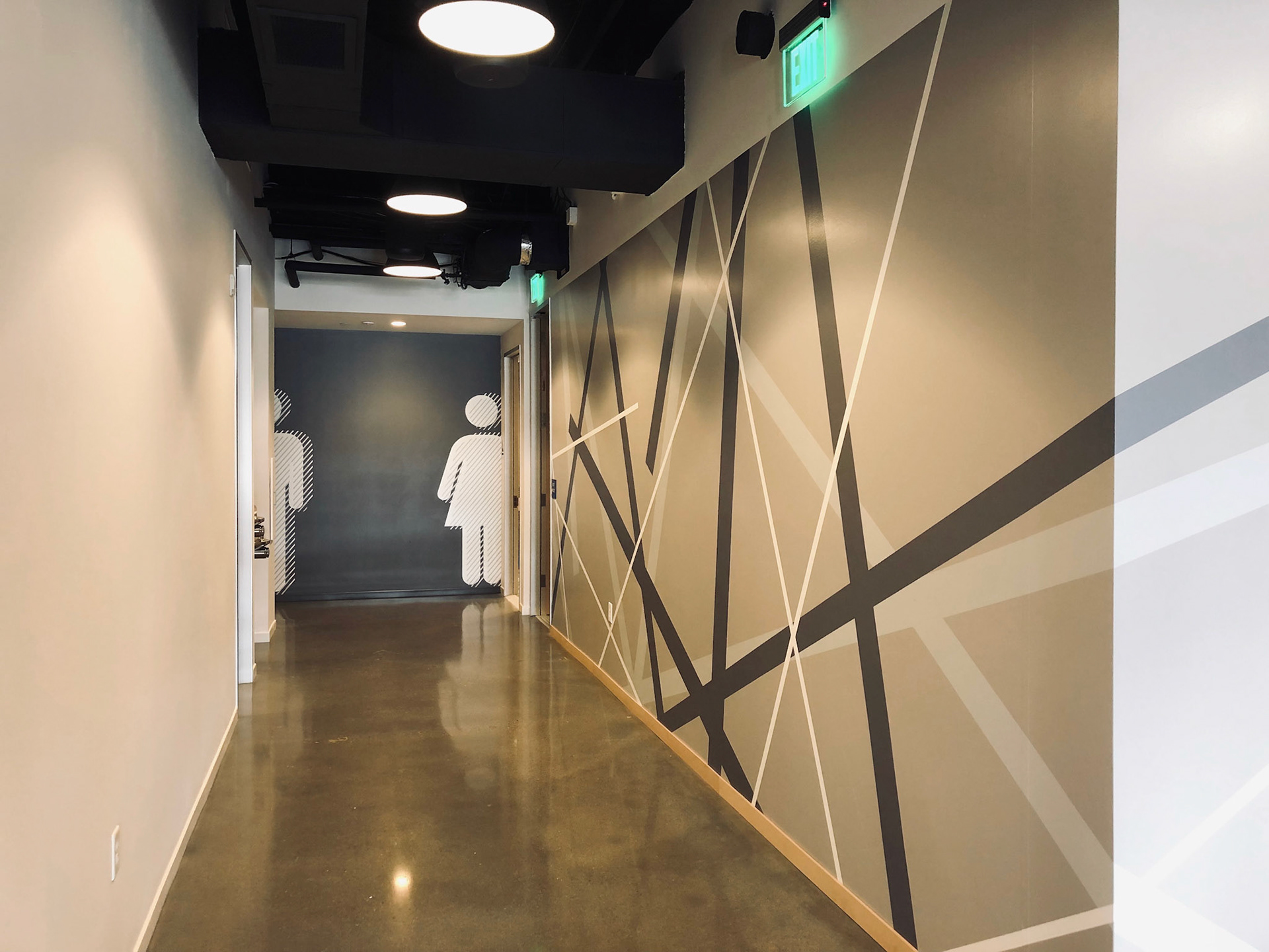Custom designed graphics line the corridor leading to the men & women restrooms